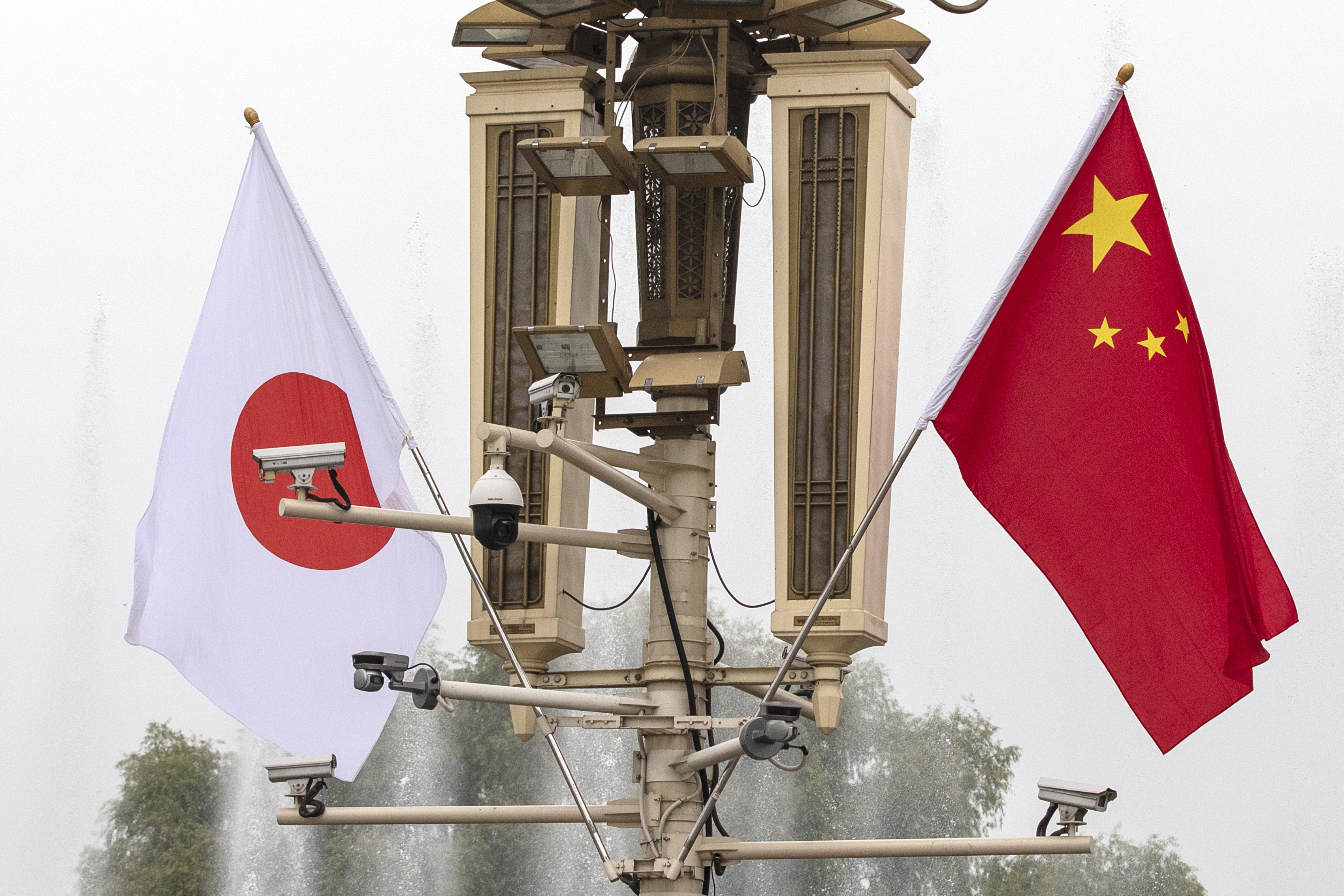 epa07118134 Surveillance cameras are seen next to national flags of Japan and China wave outside the Forbidden City to mark the visit of Japanese Prime Minister Shinzo Abe in Beijing, China, 25 October 2018. Abe is in an official visit to China from 25 to 27 October, where he will meet with Chinese high officials.  EPA/ROMAN PILIPEY