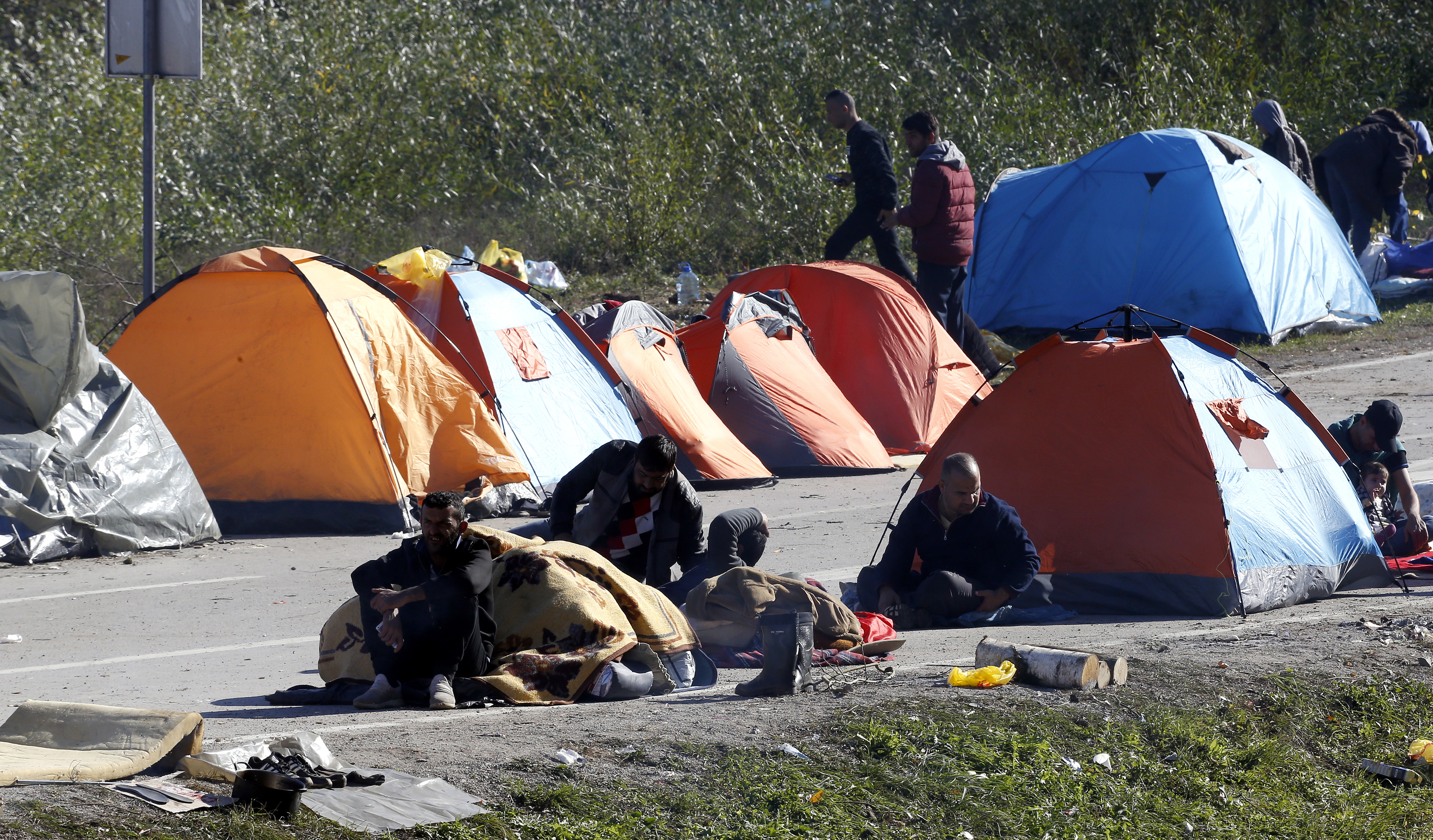 epa07119016 A group of migrants attempting to cross into Croatia gather around tents erected near the Maljevac border crossing, Bosnia and Herzegovina, 25 October 2018. According to reports, a group of some 100 migrants mostly from Afghanistan, Pakistan, and Iraq attempting to cross into Western Europe erected tents at the border area to pressure neighboring Croatia to open border and let them travel north. Thousands of migrants and refugees fleeing wars and poverty in Asia and North Africa are sleeping rough in impoverished Bosnia, and many are growing concerned about the onset of cold winter weather and a lack of adequate shelters.  EPA/FEHIM DEMIR