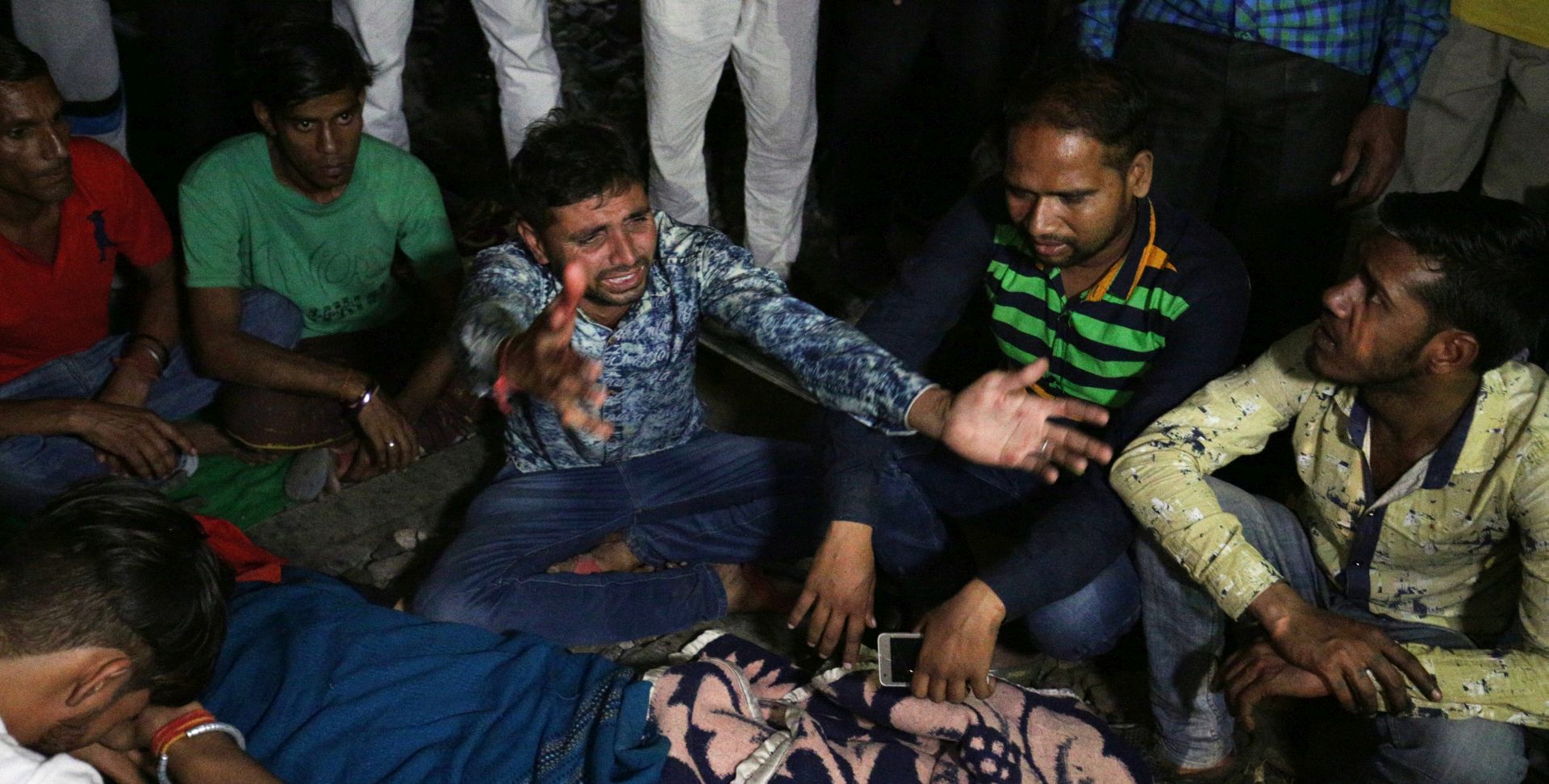 epa07105066 An Indian man cries near the dead body of his brother kept on railway track after a train accident in Amritsar, India, 19 October 2018. According to reports, at least 50 people were killed when a train ran over the a crowd that was watching the burning of Ravana effigy during Dusshera celebrations.  EPA/RAMINDER PAL SINGH