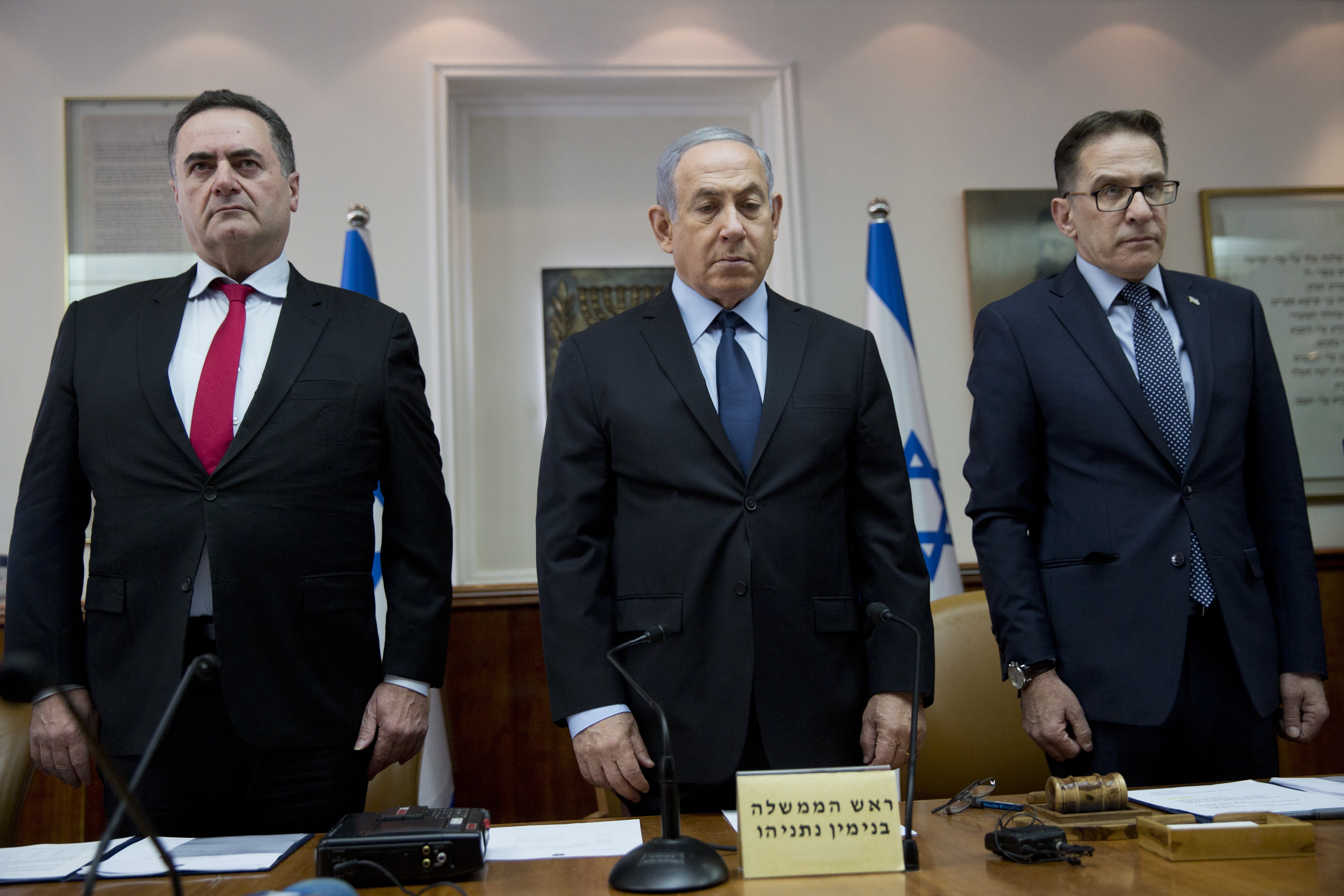 epa07126060 Israeli Prime Minister Benjamin Netanyahu (C), Minister of Transport of Israel Yisrael Katz (L) and Cabinet Secretary Tzachi Braverman (R) stand for a moment of silence for the victims of the Pittsburgh synagogue shooting attack, during the weekly cabinet meeting at the Prime Minister office in Jerusalem, 28 October 2018.  EPA/ODED BALITY / POOL POOL PHOTO