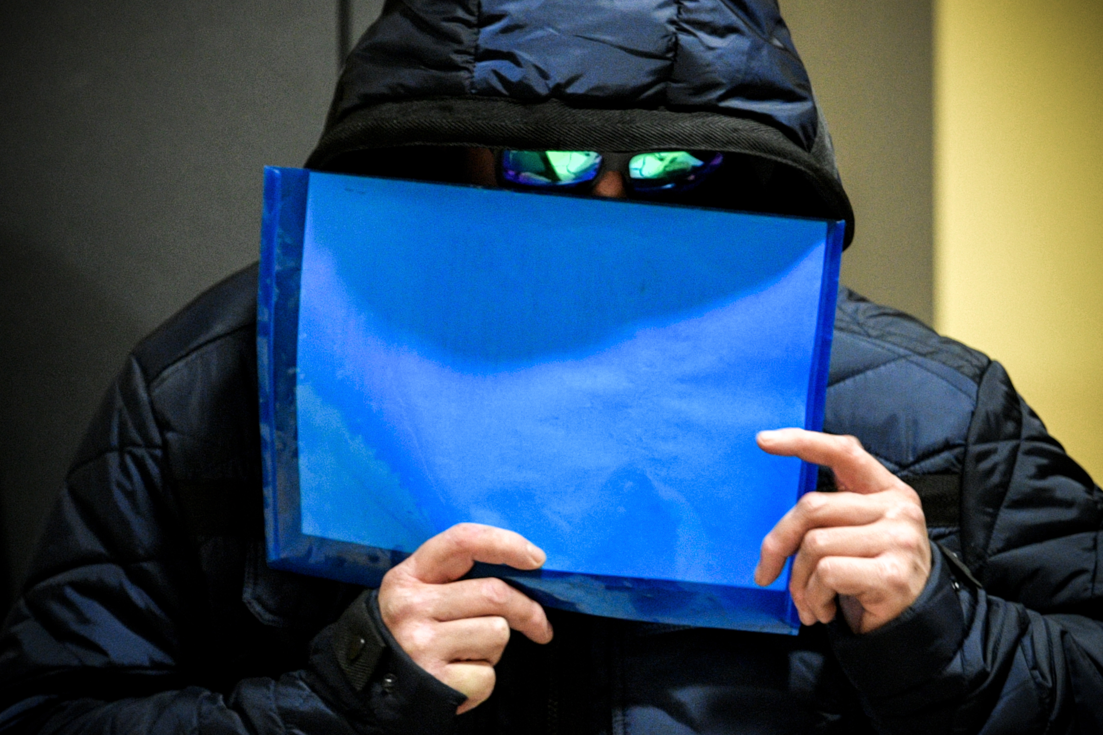epa07150127 A defendant hides his face during the 'Burbach refugee camp' trial at the Siegerlandhalle in Siegen, Germany, 08 November 2018. The public prosecutor's office accuses 32 defendants of 54 cases of deprivation of liberty, assault, coercion and theft. Because of space constraints, the trial took place at the Siegerlandhalle.  EPA/SASCHA STEINBACH