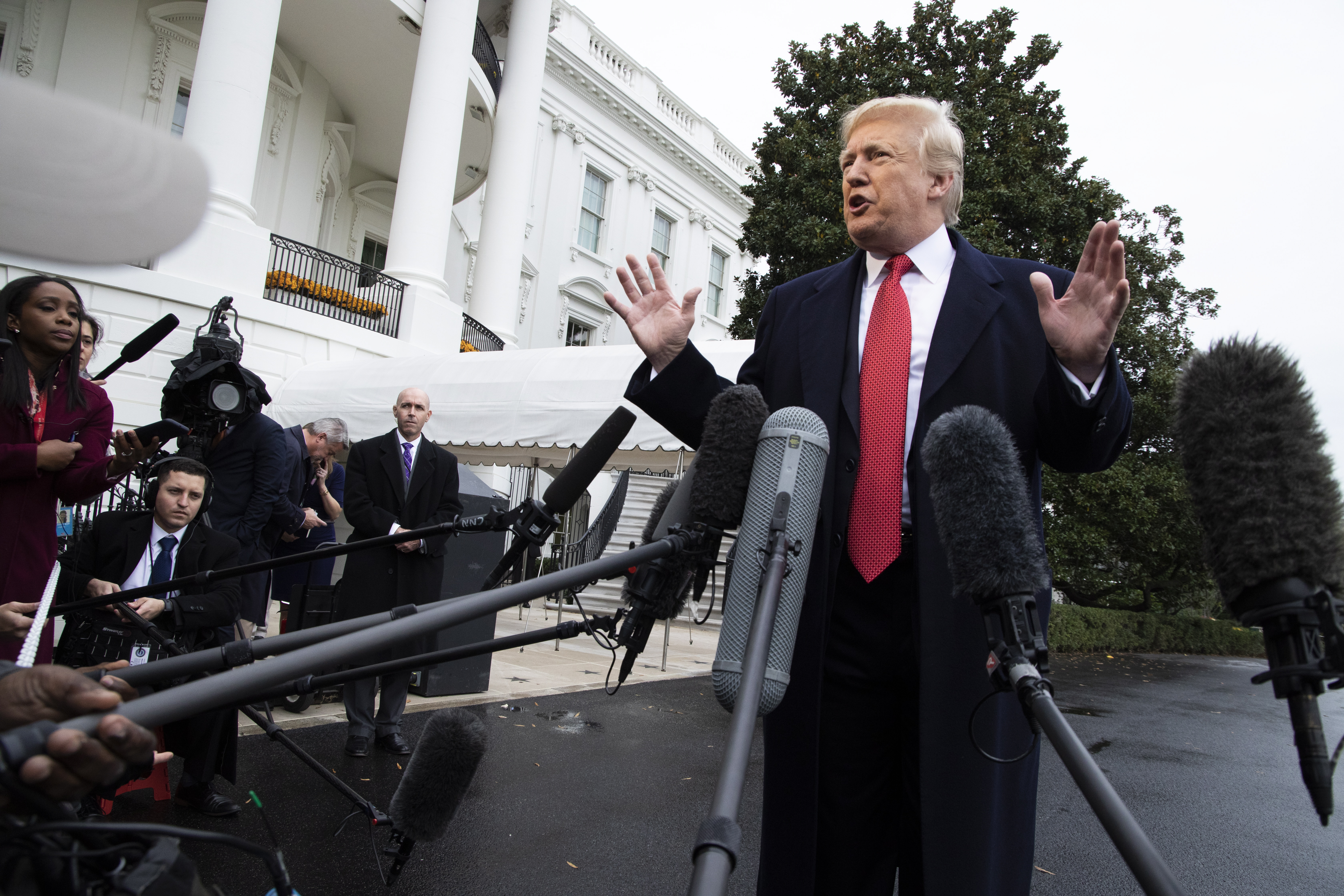 epa07153452 US President Donald J. Trump responds to a question from the news media as he walks to board Marine One on the South Lawn of the White House in Washington, DC, USA, 09 November 2018. President Trump is departing for Paris for a ceremony commemorating 100 years since the end of World War I on 11 November.  EPA/SHAWN THEW