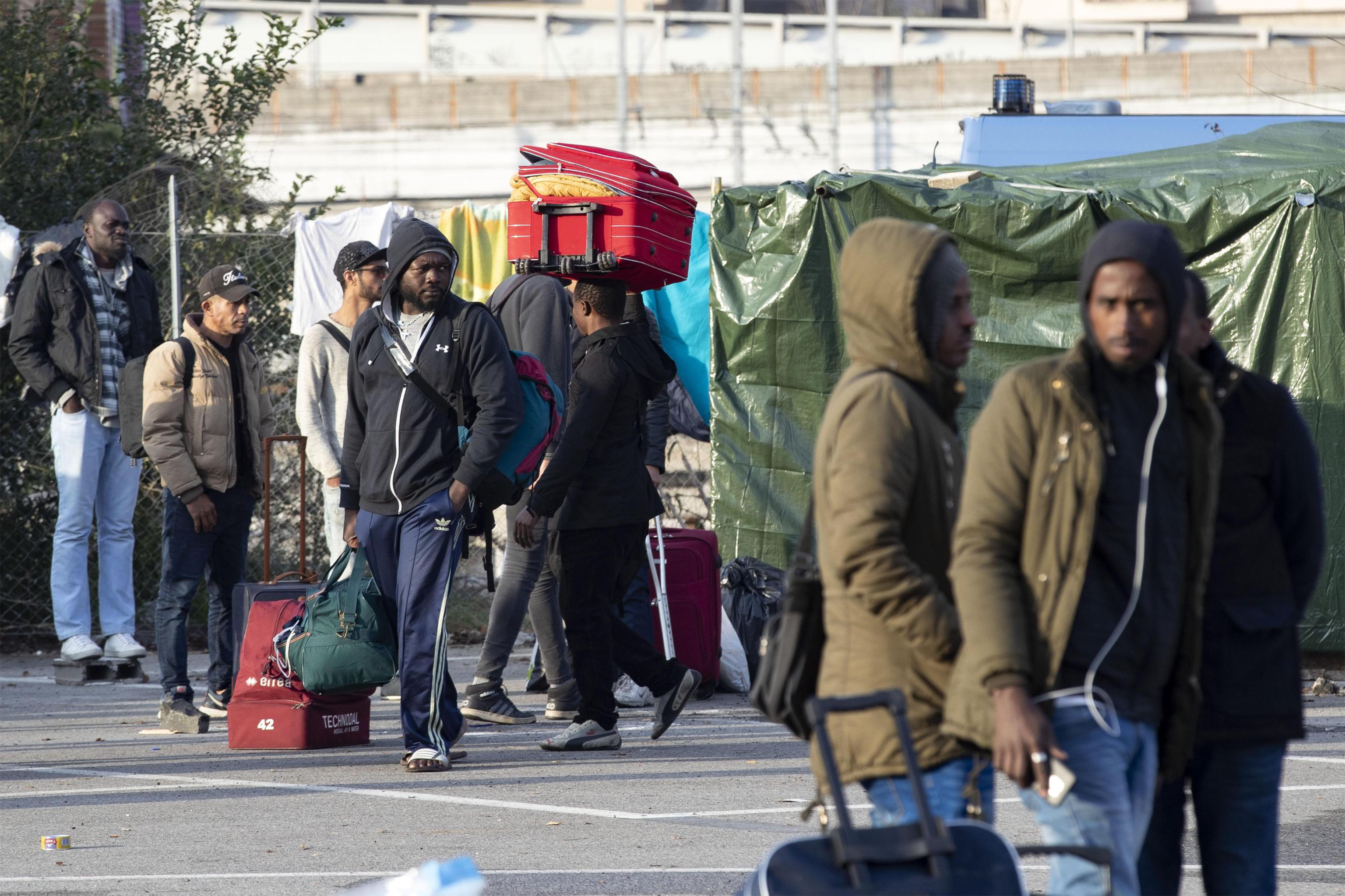 epa07162369 People carry their belongings as authorities clear the migrants camp run by volunteers providing food and shelter to migrants near to Rome's Tiburtina railway station, Rome, Italy, 13 November 2018. Around 200 migrants were in the Baobab Experience camp before the eviction.  EPA/MASSIMO PERCOSSI