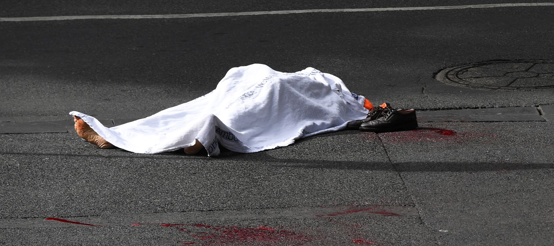 epa07152631 A deceased person is seen on Bourke street after an incident in Melbourne, Australia, 09 November 2018. According to early media reports, an unidentified man set a vehicle alight and stabbed two people before being shot by police in the Central Business District of Melbourne. At least one person was killed during the incident. The perpetrator was taken into custody and is reportedly in critical condition.  EPA/JAMES ROSS AUSTRALIA AND NEW ZEALAND OUT