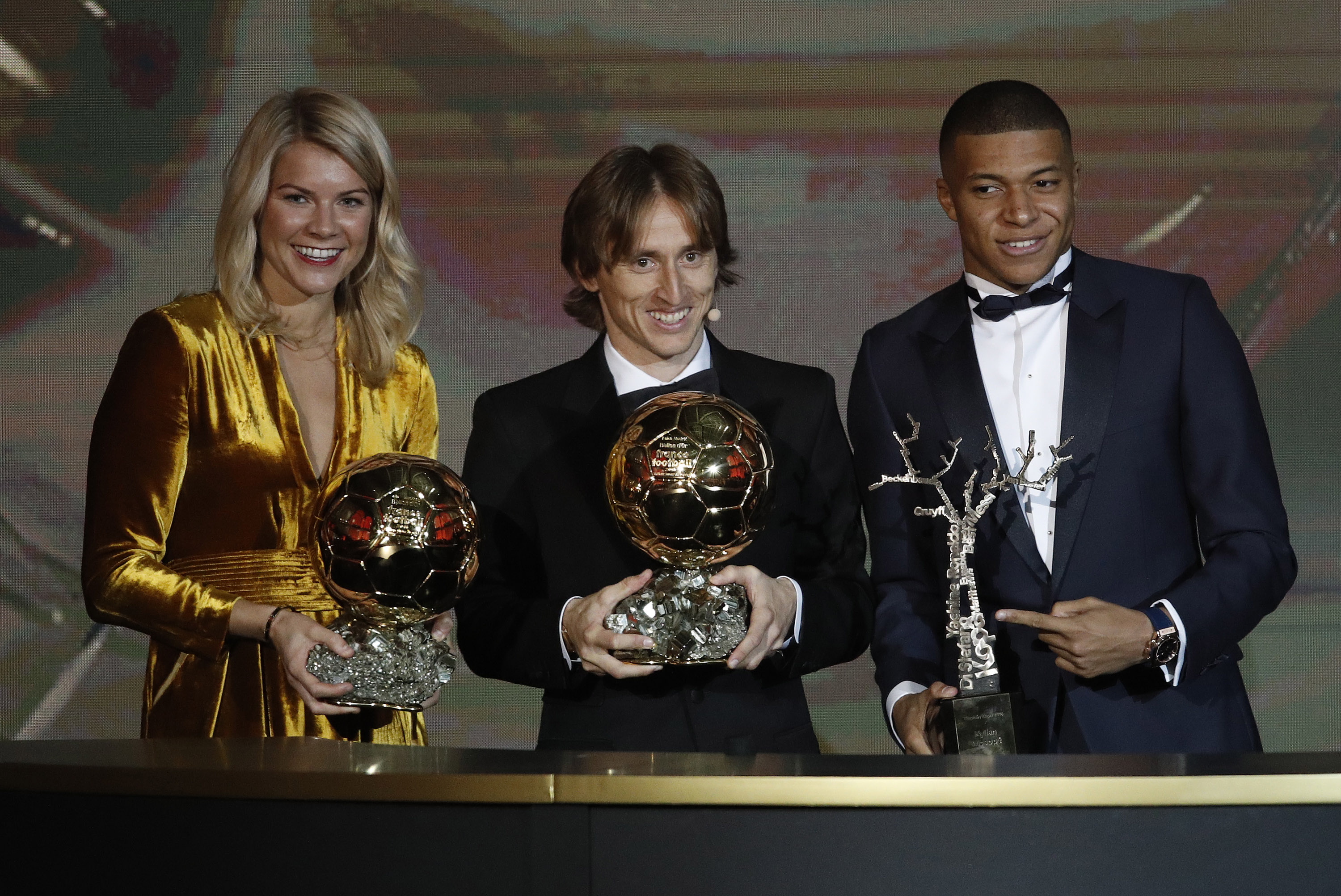 epa07206921 (L-R) Olympique Lyonnais' Ada Hegerberg, Real Madrid's Luka Modric and Paris St Germain's Kylian Mbappe holds their 'Ballon d'Or' (Golden ball) trophies during the ceremony rewarding the best European footballer of the year in Paris, France, 03 December 2018.  EPA/YOAN VALAT