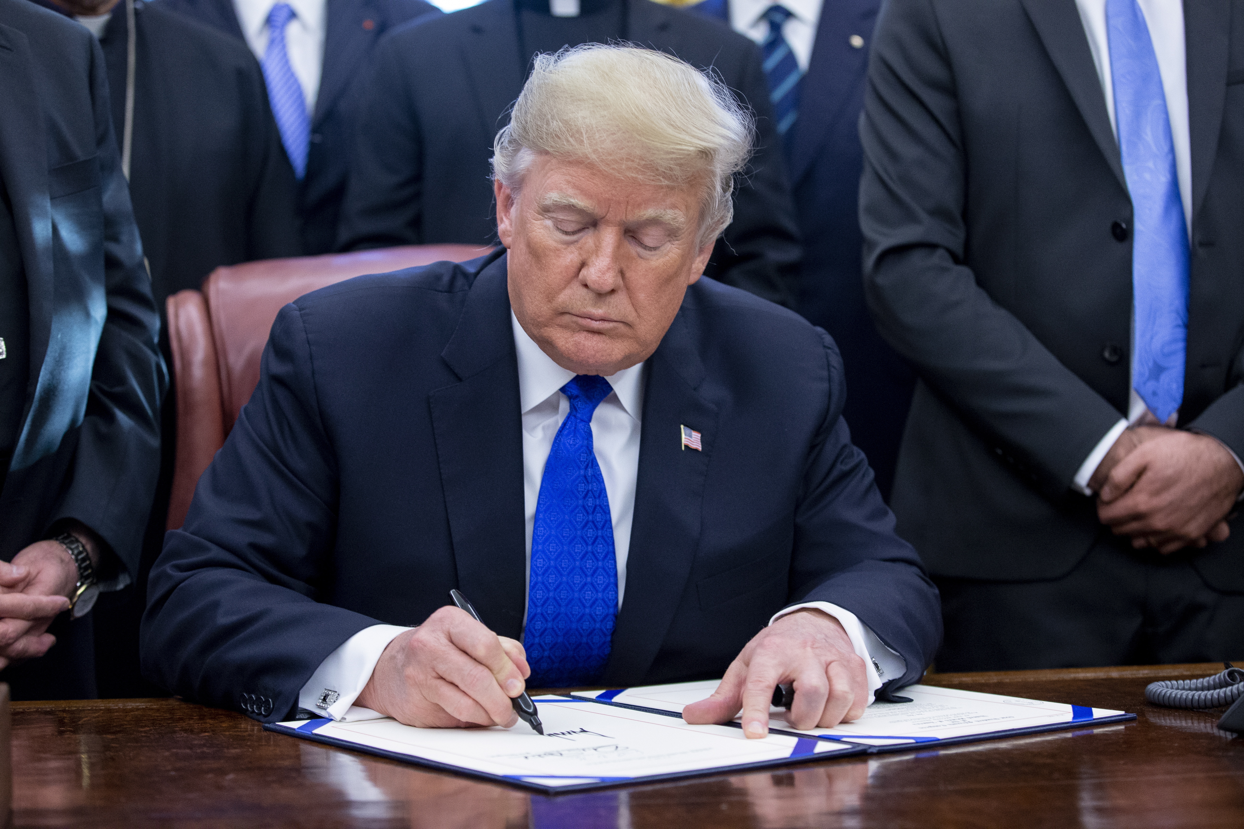 epa07224609 US President Donald J. Trump signs H.R. 390, the 'Iraq and Syria Genocide Relief and Accountability Act of 2018', in the Oval Office of the White House in Washington, DC, USA, 11 December 2018. The law will provide emergency humanitarian and recovery assistance to victims of crimes against humanity, war crimes and genocide in Iraq and Syria. The legislation also directs the US State Department to preserve evidence of genocide in those regions.  EPA/MICHAEL REYNOLDS