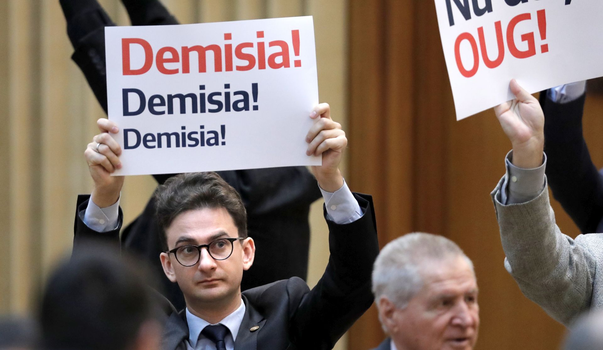 epa07241945 A Romanian lawmaker wave a placard   as protestind during a a no-confidence vote procedure against Dancila cabinet, held at Parlament Palace in Bucharest, Romania, 20 December 2018. The opposition parties pushed a no-confidence vote against the ruling coalition despite low mathematical chances to pass it trough parliament. Romania is preparing to take the Presidency of the Council of the European Union for six months, starting on 01 January 2019. The placard writes: 'RESIGNATION!'.  EPA/ROBERT GHEMENT