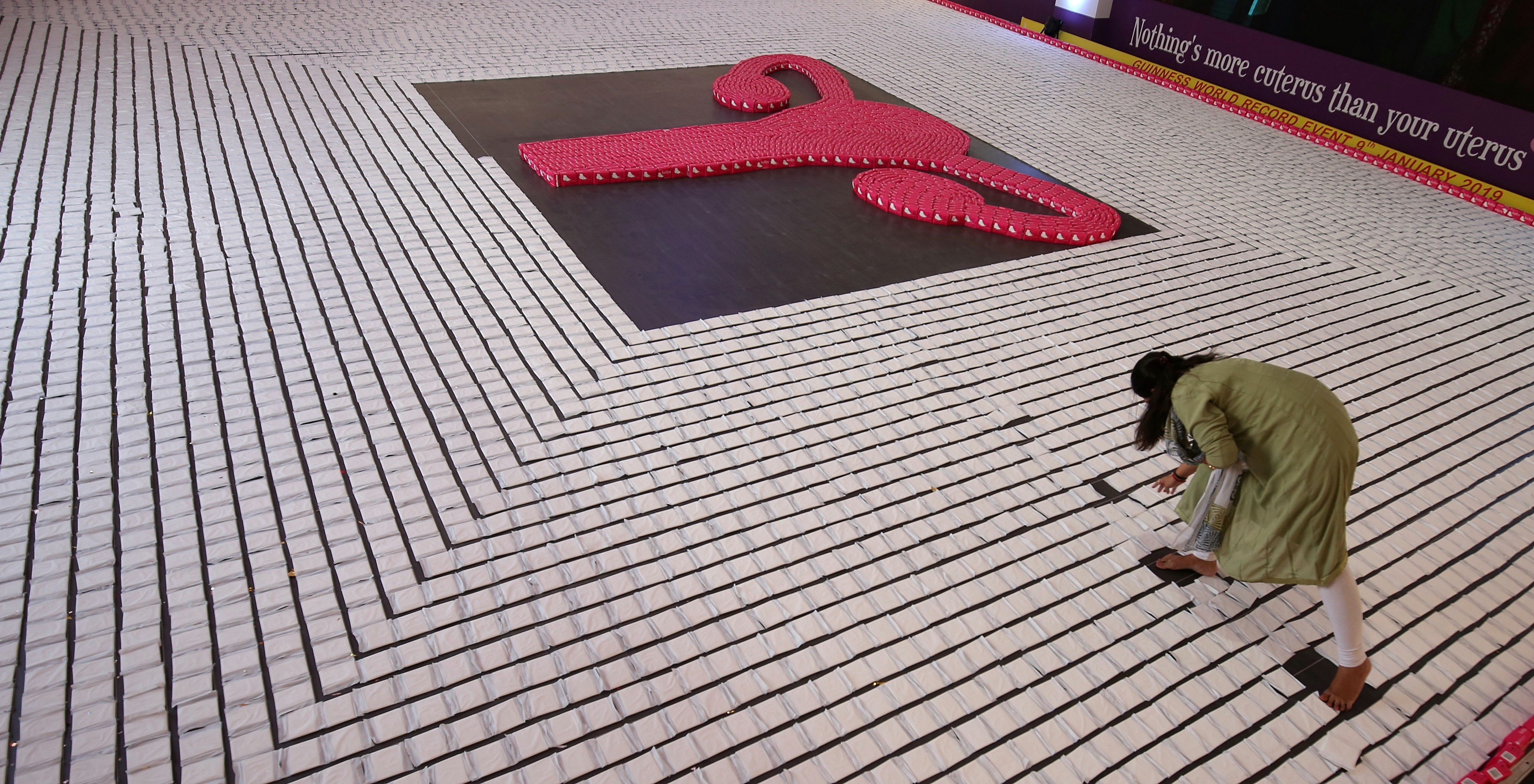 epa07273270 An Indian woman arrange the sanitary napkins during a successful attempt for a Guinness world record by creating the 'longest line of sanitary pads', at the 62nd All India Congress of Obstetrics and Gynaecology (AICOG) in Bangalore, India, 10 January 2019. Over 1,500 gynaecologists have formed a line of 1,078 metres using 10,105 sanitary pads. Depicting women's health, the sanitary pads were designed in the shape of a uterus and carried the tagline 
Nothing's more cuterus than your uterus  EPA/JAGADEESH NV