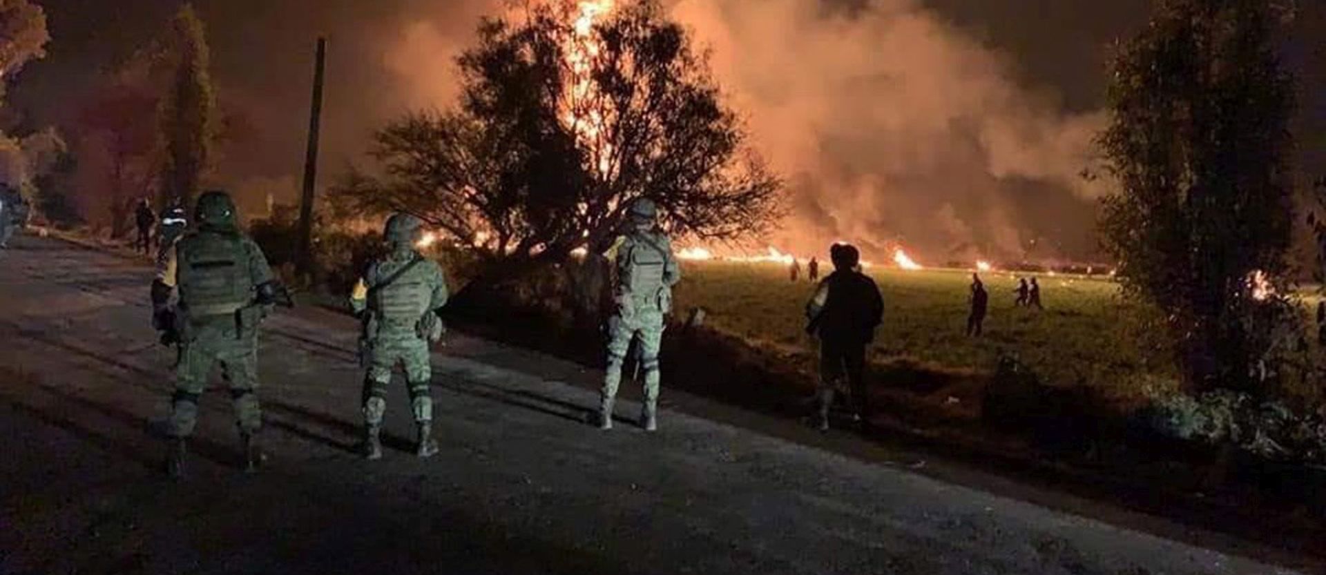 epa07298957 Several soldiers stand guard next to a huge fire that broke out after the explosion of an illegal tap on Mexican oil company Pemex's pipeline in Tlahuilipan, state of Hidalgo, Mexico, late night 18 January 2019. At least 21 people died and 71 other people were wounded in the blast, according to official sources.  EPA/OASA BEST QUALITY AVAILABLE