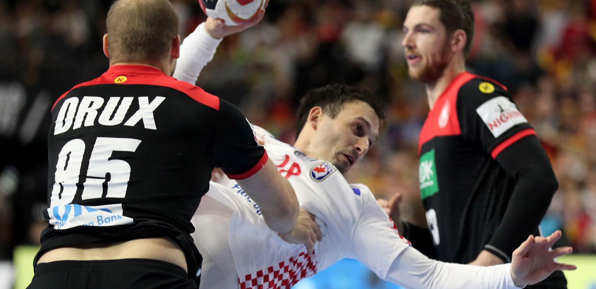 epa07307335 Igor Karacic (C) of Croatia in action against Paul Drux (L) of Germany during the main round group one match between Croatia and Germany at the IHF Men's Handball World Championship in Cologne, Germany, 21 January 2019.  EPA/FRIEDEMANN VOGEL