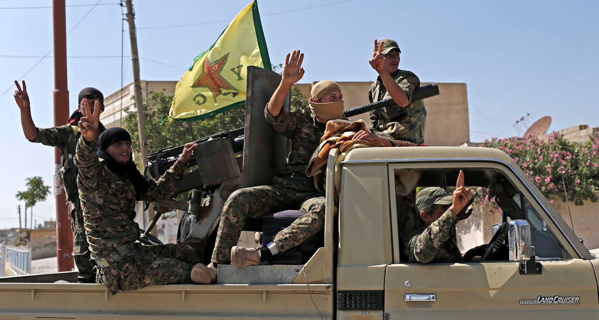epa07251367 (FILE) - Members of Kurdish People Defence Units (YPG) flash victory sign after coming from Syrian town of al-Raqqa, in Tel Abyad, Syria, 23 June 2015 (Reissued 28 December 2018). According to reports on 28 December 2018, The US-backed Kurdish People's Protection Units (YPG) and the Syrian Democratic Forces (SDF), which control a 250km territory in northern Syria, asked Assad's Syrian army to take over control of Manbij town in order to protect it from a potential Turkish attack. On 19 December 2018 US President Donald J. Trump announced the withdrawal of US forces from Syria, and on 24 December 2018 he said that Turkey will be clearing the last of IS pockets in Syria. Turkey classifies the YPG and SDF as terrorist organizations.  EPA/SEDAT SUNA *** Local Caption *** 52022361