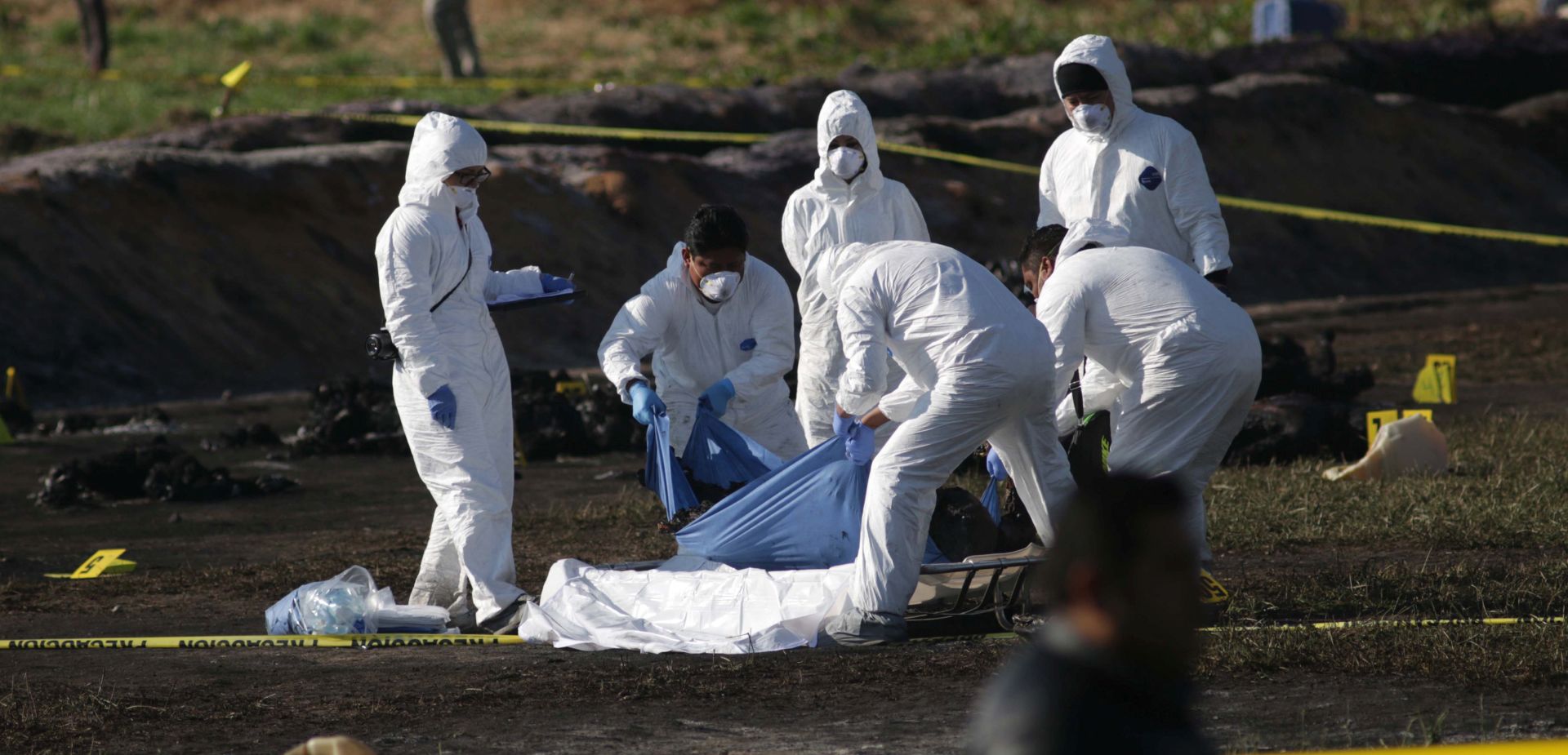 epa07300777 Forensic officials work at the site following the explosion at an illegal tap on Mexican oil company Pemex's pipeline in Tlahuilipan, state of Hidalgo, Mexico, 19 January 2019. At least 66 people died and 76 other were injured, according to official sources.  EPA/Jorge Dan Lopez