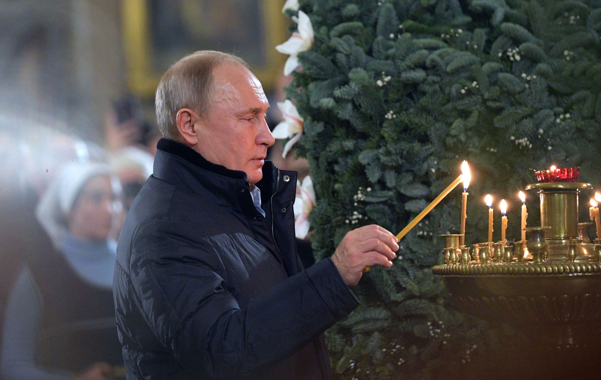epa07266508 Russian President Vladimir Putin lights a candle during a Christmas service at the Cathedral of the Transfiguration of the Savior of All the Guards in St. Petersburg, Russia, 06 January 2019. The Russian Orthodox church celebrates Christmas on 07 January following the Julian calendar.  EPA/ALEXEI DRUZHININ / SPUTNIK / KREMLIN POOL SPUTNIK POOL
