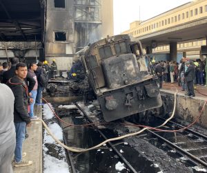 epa07400366 A destroyed train restst on tracks at the main train station in Cairo, Egypt, 27 February 2019. Local media reports state at least ten people died and 22 were injured after a large fire engulfed an area at the main train station, possible triggered by an explosion of a fuel tank of a passing train. It is feared the number of casualties could rise.  EPA/KHALED ELFIQI