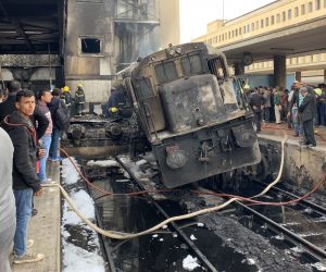 epa07400366 A destroyed train restst on tracks at the main train station in Cairo, Egypt, 27 February 2019. Local media reports state at least ten people died and 22 were injured after a large fire engulfed an area at the main train station, possible triggered by an explosion of a fuel tank of a passing train. It is feared the number of casualties could rise.  EPA/KHALED ELFIQI