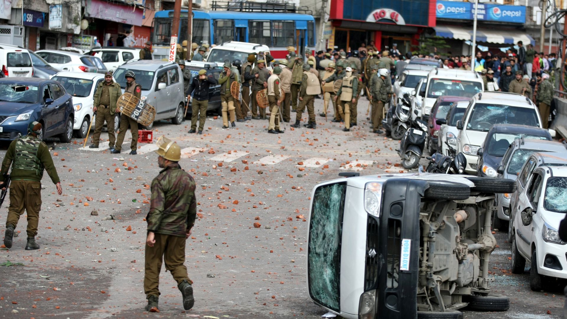 epa07371776 Jammu and Kashmir policemen stand near damaged vehicles during a protest against the terror attack that killed over forty Central Reserve Police Force (CRPF) personnel in Pulwama in Jammu, the winter capital of Kashmir, India, 15 February 2019. A curfew was imposed in parts of Jammu city following massive protests over the terror attack in Pulwama, according to the news reports more than 50 vehicles have been vandalised and eight vehicles set ablaze by the angry mob. At least 44 Indian paramilitary Central Reserve Police Force personnel were killed and several injured when a Jaish-e-Mohammed militant rammed an explosive-laden vehicle into a CRPF convoy along Srinagar-Jammu highway at Lethpora area in south Kashmir's Pulwama district on 14 February 2019, according local media reports.  EPA/JAIPAL SINGH
