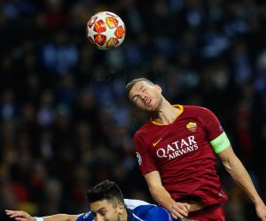 epa07418240 FC Porto's Alex Telles (L) in action against Roma Edin Dzeko during their Champions League lround of 16 second leg soccer match, held at Dragao stadium, Porto, Portugal, 6 March 2019.  EPA/JOSE COELHO