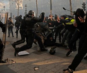 epa07443444 Yellow Vests protesters hit a riot police officer (C down) on the Champs Elysees during the 'Act XVIII' demonstration (the 18th consecutive national protest on a Saturday) in Paris, France, 16 March 2019. The so-called 'gilets jaunes' (yellow vests) is a grassroots protest movement with supporters from a wide span of the political spectrum, that originally started with protest across the nation in late 2018 against high fuel prices. The movement in the meantime also protests the French government's tax reforms, the increasing costs of living and some even call for the resignation of French President Emmanuel Macron.  EPA/YOAN VALAT