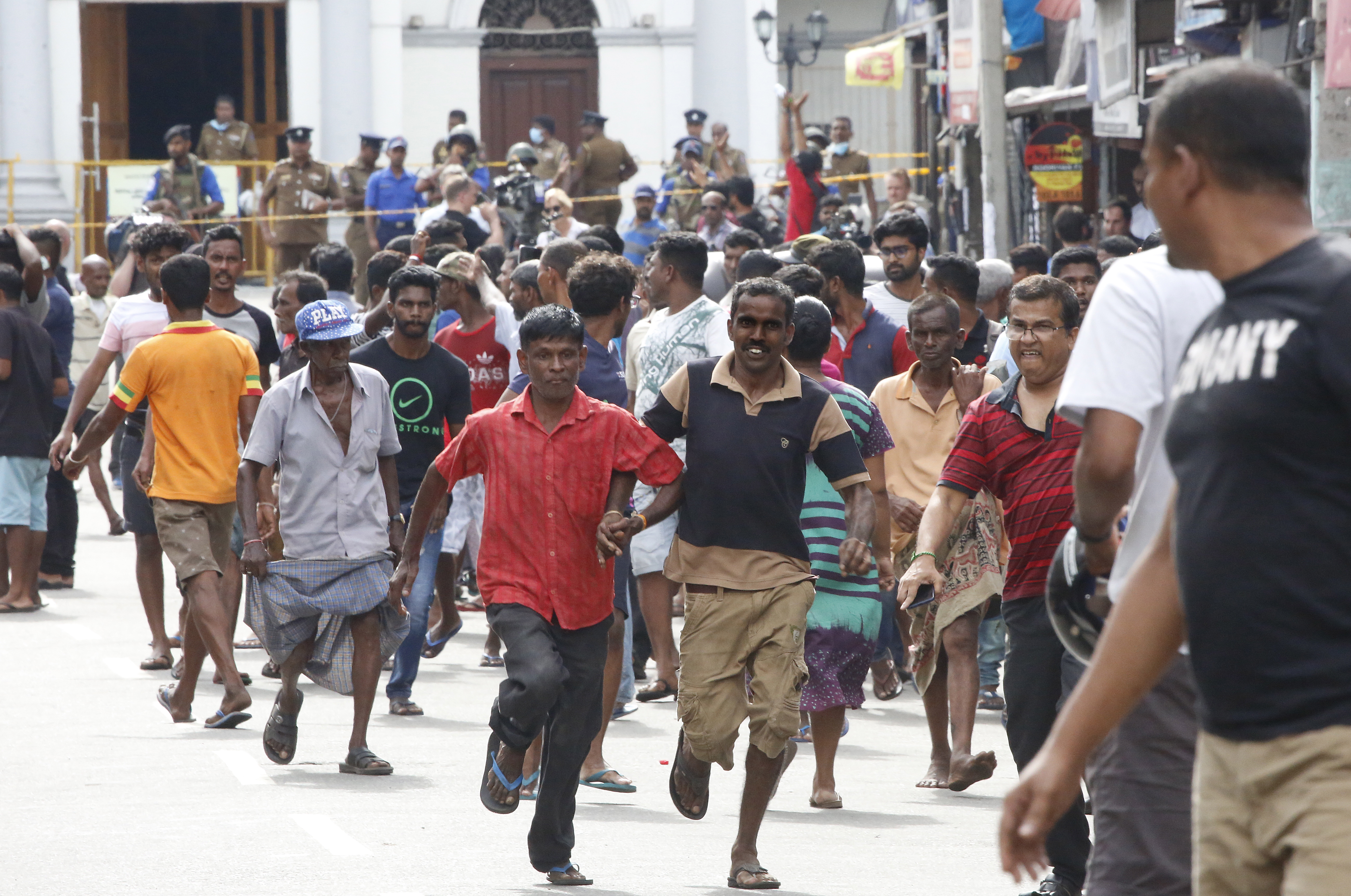 epa07521264 Sri Lankan people run for safety as authorities announced an evacuation of the area after a van was found parked with a suspected explosive device near  St Anthony's Church  Kochchikade in Colombo, Sri Lanka, 22 April 2019.  According to news reports, at least 290 people have been killed and over 500 were injured on 21 April 2019 in a series of blasts during Easter Sunday service at churches and hotels across Colombo.   EPA/M.A. PUSHPA KUMARA