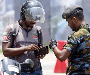 epa07526913 A Sri Lankan security officer checks driver's identity proof in Colombo, Sri Lanka, 25 April 2019. According to the news reports, most public places have no people around as security agencies continue to find suspected bomb detonators after at least 320 people were killed in a coordinated series of blasts during the Easter Sunday service at churches and hotels in Sri Lanka on 21 April 2019.  EPA/M.A. PUSHPA KUMARA