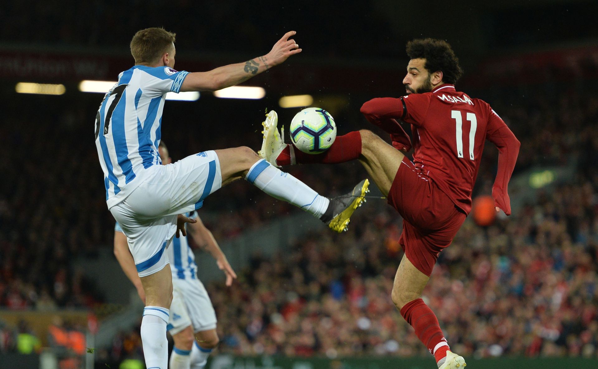 epa07530956 Liverpool's Mohamed Salah (R) vies for the ball against Huddersfield Erik Durm (L) during the English Premier League match between Liverpool FC and Huddersfield  at Anfield, Liverpool, Britain, 26 April 2019.  EPA/PETER POWELL EDITORIAL USE ONLY. No use with unauthorized audio, video, data, fixture lists, club/league logos or 'live' services. Online in-match use limited to 120 images, no video emulation. No use in betting, games or single club/league/player publications