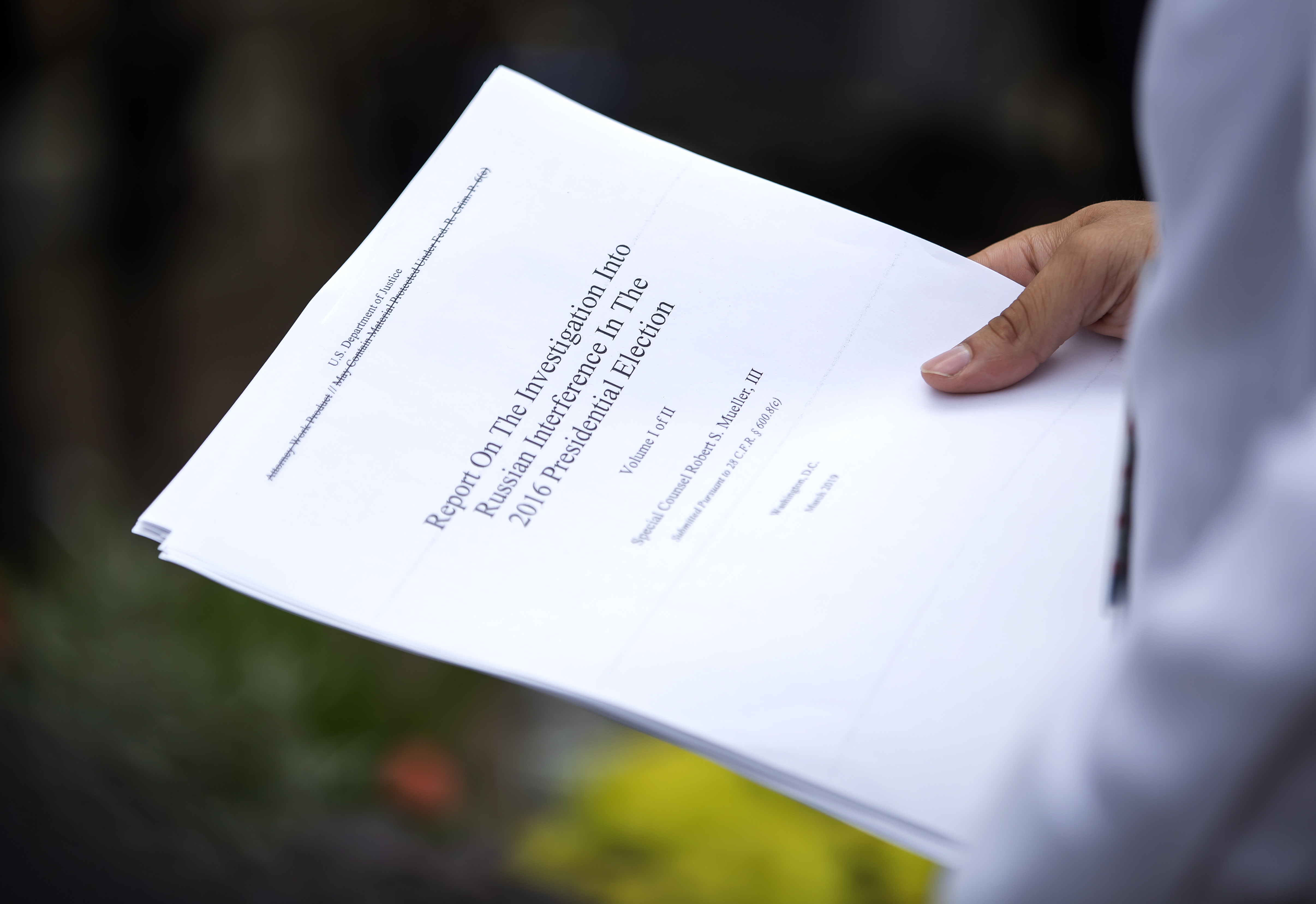 epa07514219 A reporter holds a printout of the redacted version of Special Counsel Robert Mueller's report on Russian interference in the 2016 election minutes after its release outside the US Department of Justice in Washington, DC, USA, 18 April 2019. According to news reports, Mueller and his team could not conclude that US President Donald J. Trump obstructed justice during the investigation.  EPA/ERIK S. LESSER