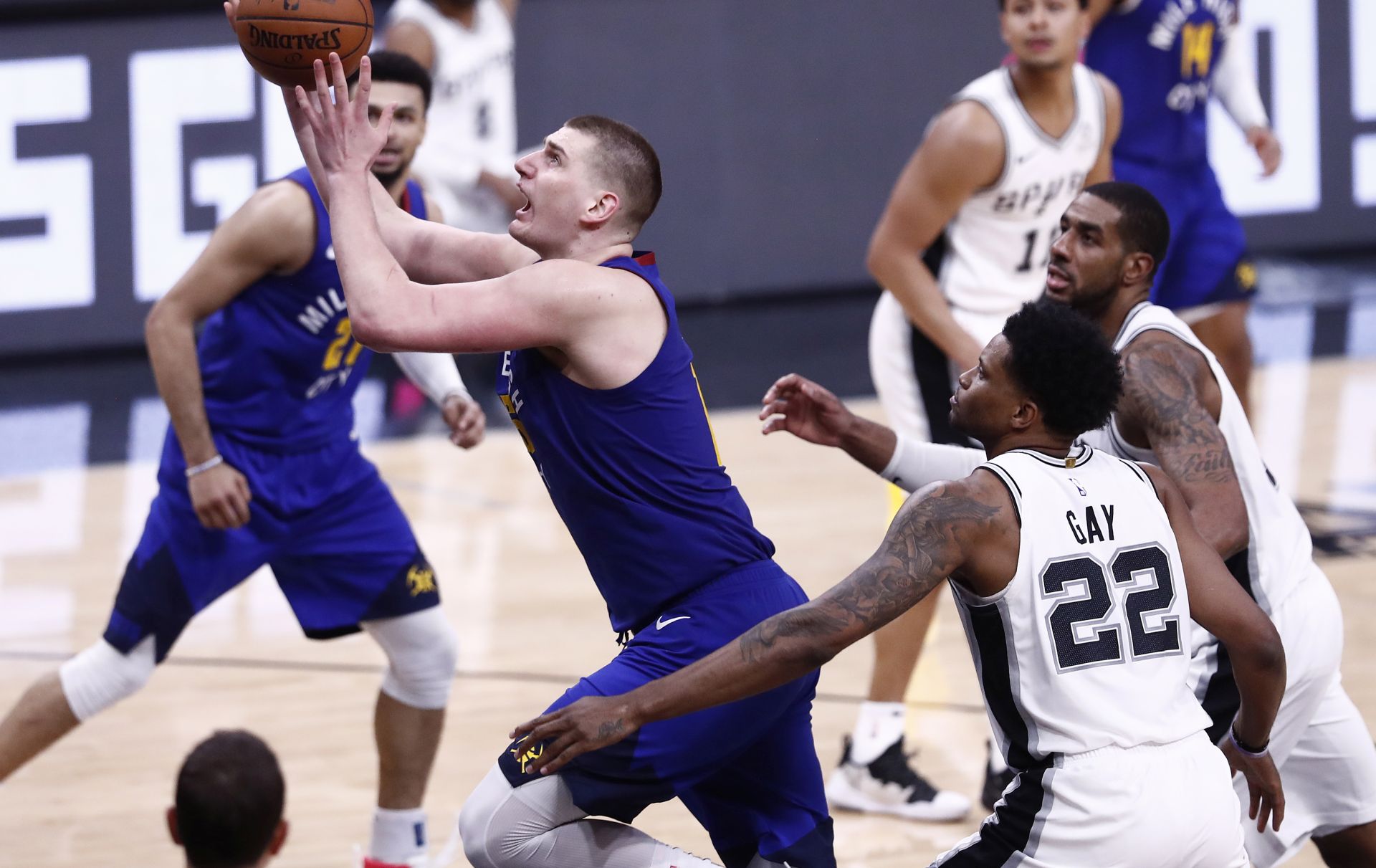 epa07518493 Denver Nuggets player Nikola Jokic of Serbia (L) goes to the basket against San Antonio Spurs players Rudy Gay (C) and LaMarcus Aldridge (R) during the NBA Western Conference Playoffs game four at the AT&T Center in San Antonio, Texas, USA, 20 April 2019.  EPA/LARRY W. SMITH SHUTTERSTOCK OUT SHUTTERSTOCK OUT