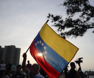 epa07538017 Sympathizers of Venezuelan interim President Juan Guaido wave the Venezuelan national flag outside the military base of La Carlota, in Caracas, Venezuela, 30 April 2019 where Guaido remains inside backed by a group of military personnel. Reports state that at least one person was injured during the clashes at La Carlota after Guaido called for mass anti-government protests backed by the military. Venezuelan interim President Juan Guaido has asked supporters to take to the streets in order to end the regime of President Nicolas Maduro. Meanwhile, Venezuelan opposition leader Leopoldo Lopez was freed from his house arrest, appearing alongside Guaido and military forces in Caracas.  EPA/Miguel Gutierrez