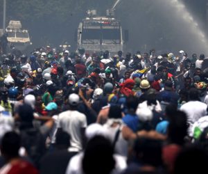 epa07538456 Supporters of President of the Venezuelan Parliament confront armored trucks of the Bolivarian Armed Forces during a protest at the Altamira area, in Caracas, Venezuela, 30 April 2019. Venezuelan interim President Juan Guaido has asked supporters to take to the streets in order to end the regime of President Nicolas Maduro. Meanwhile, Venezuelan opposition leader Leopoldo Lopez was freed from his house arrest, appearing alongside Guaido and military forces in Caracas.  EPA/Miguel Gutierrez