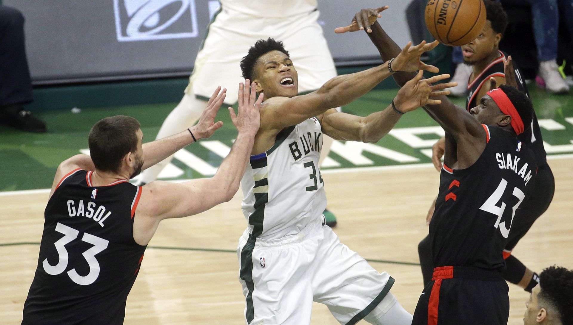 epa07579893 Milwaukee Bucks forward Giannis Antetokounmpo (C) of Greece passes the ball between Toronto Raptors center Marc Gasol (L) and Toronto Raptors forward Pascal Siakam (R) of Cameroon during game 2 of the NBA Eastern Conference finals between the Toronto Raptors and the Milwaukee Bucks at Fiserv Forum in Milwaukee, Wisconsin, USA, 17 May 2019.  EPA/AARON GASH SHUTTERSTOCK OUT