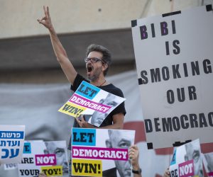 epa07581933 A man shouts slogans as Israelis hold a protest against Israeli Prime Minister Benjamin Netanyahu, outside of the fairgrounds where the Eurovision 2019 song festival is taking place in Tel Aviv, Israel, 18 May 2019. Several dozen Israelis held the protest against the prime minister who is tasked with forming the next Israeli government although he faces indictment on three different counts including bribery.  EPA/JIM HOLLANDER
