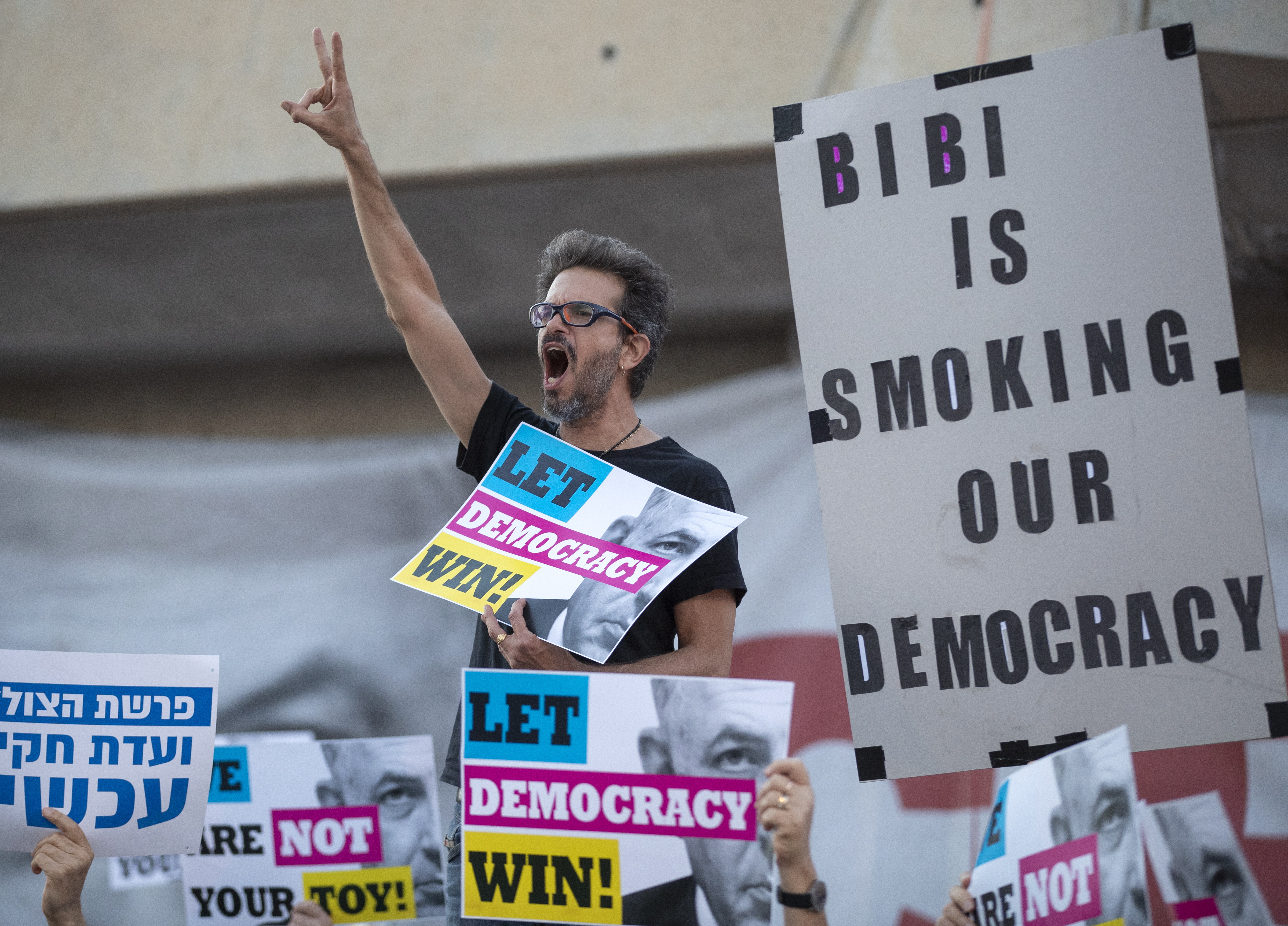 epa07581933 A man shouts slogans as Israelis hold a protest against Israeli Prime Minister Benjamin Netanyahu, outside of the fairgrounds where the Eurovision 2019 song festival is taking place in Tel Aviv, Israel, 18 May 2019. Several dozen Israelis held the protest against the prime minister who is tasked with forming the next Israeli government although he faces indictment on three different counts including bribery.  EPA/JIM HOLLANDER