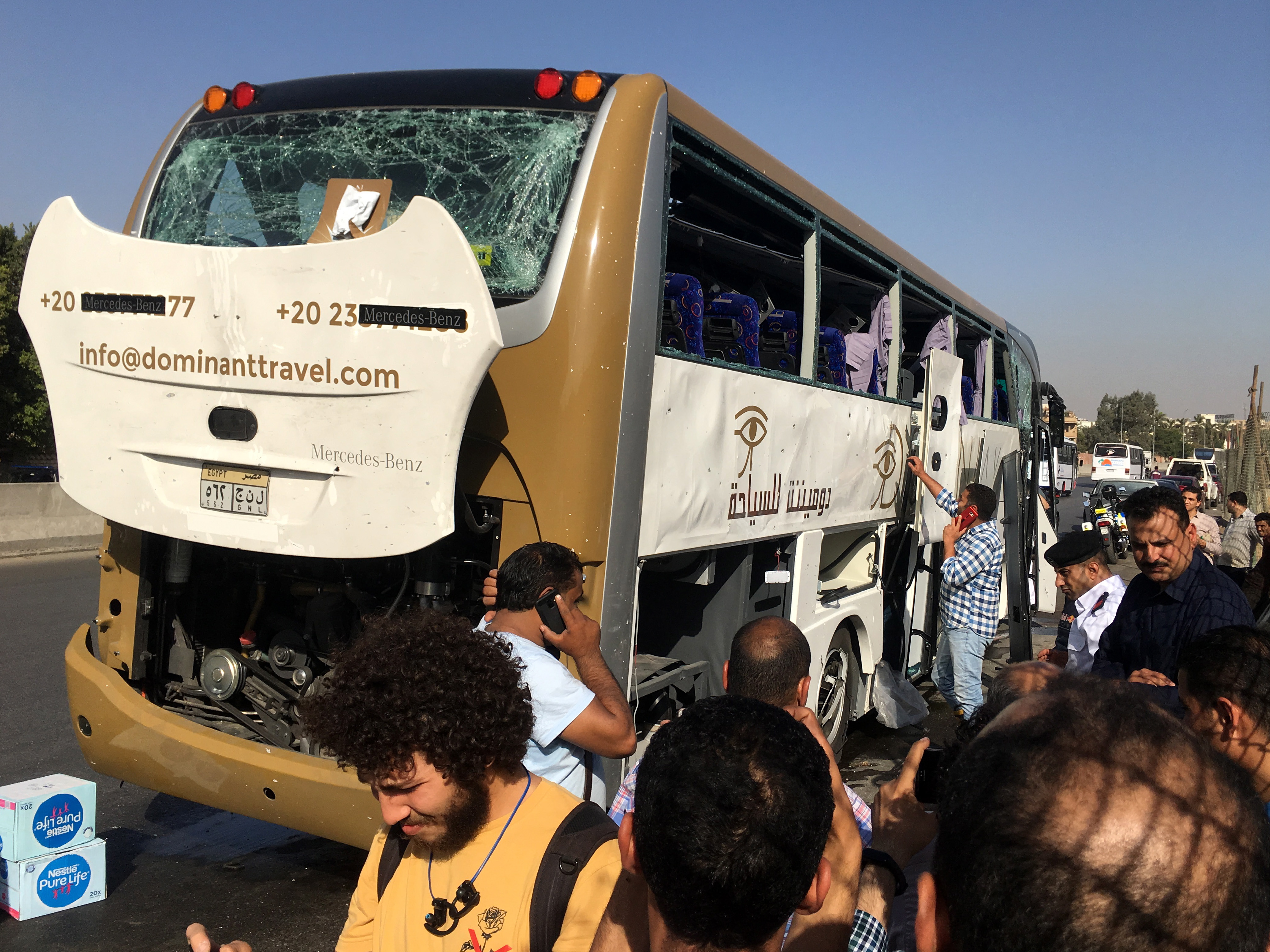epa07584517 Security officials stand next to a tourists' bus that was targeted by an explosive device near Grand Egyptian Museum in Giza, Egypt, 19 May 2019. According to reports, 16 people, mostly tourists, were injured when an explosive device went off as the bus was driving near the fence of the museum.  EPA/MOHAMED HOSSAM