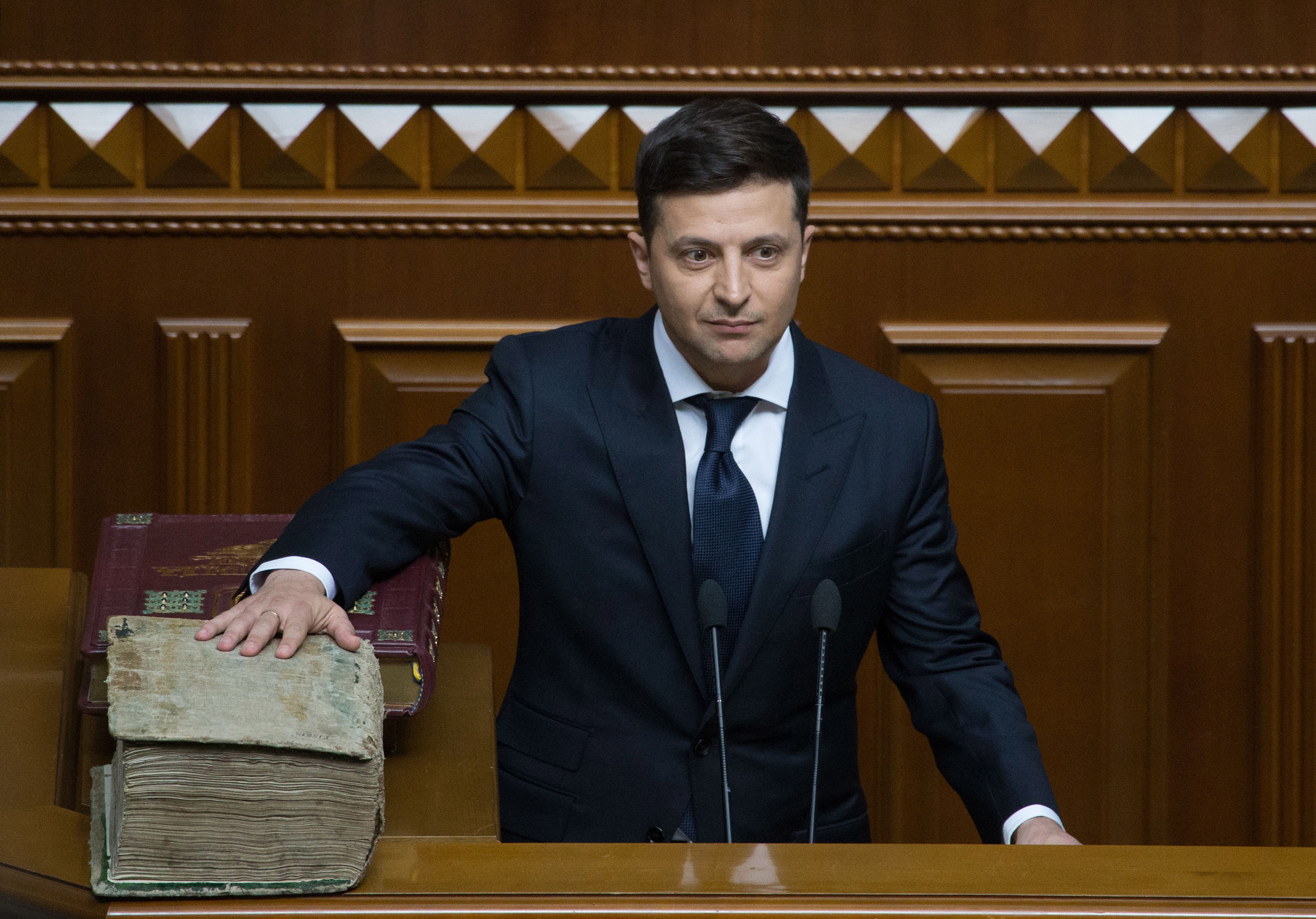 epa07586231 A handout photo made available by the Presidential Press Service on 20 May 2019 shows President-elect Volodymyr Zelensky reads an oath putting his hand on the Holy Bible during his inauguration in the Ukrainian parliament in Kiev, Ukraine, 20 May 2019. Volodymyr Zelensky with 73,22 percent of the votes beats out the current President Petro Poroshenko, who received 24,45 percent of the votes during the second tour of Presidential elections in Ukraine which was held on 21 April 2019.  EPA/MYKHAILO MARKIV/ PPS HANDOUT  HANDOUT EDITORIAL USE ONLY/NO SALES