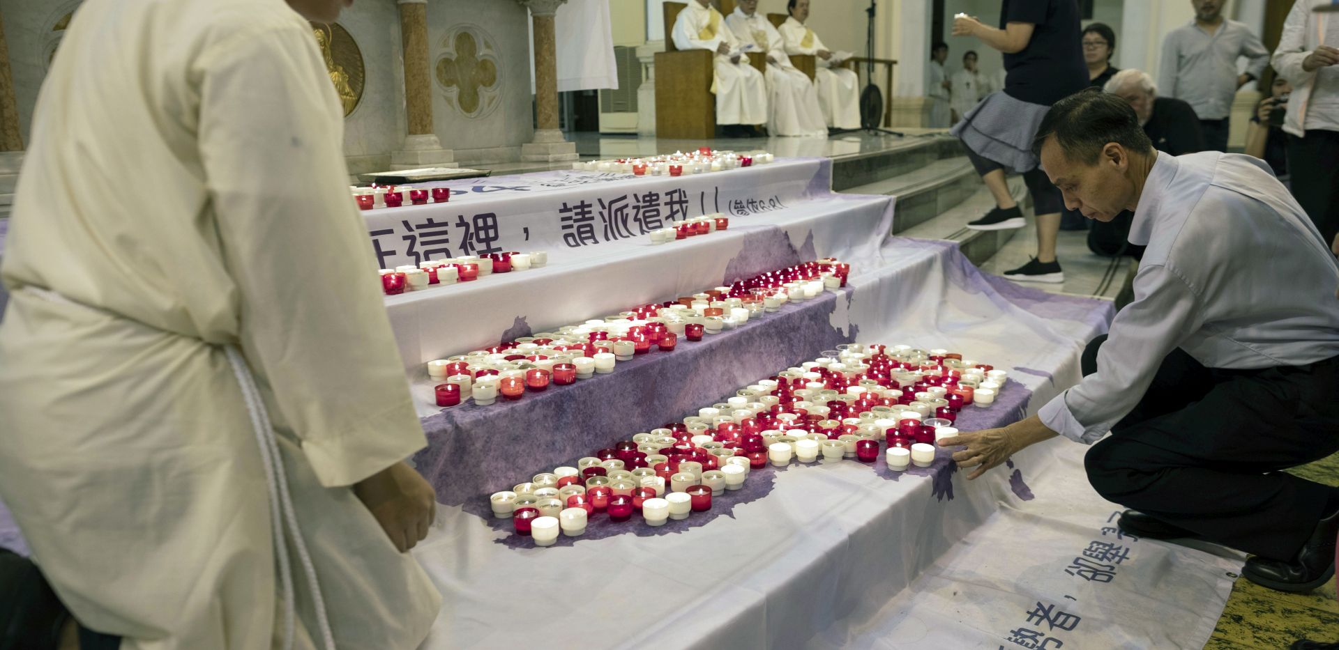 epa07616784 Worshippers put candles on a banner showing a map of China in from of the altar during a mass commemorating the 30th anniversary of the 1989 Beijing Tiananmen Massacre in Hong Kong, China, 31 May 2019, (issued 01 June 2019). The Justice and Peace Commission of the Hong Kong Catholic Diocese held a mass officiated by Cardinal Joseph Zen Ze-kiun. Zen, who outspoken on issues regarding human rights, political freedom, and religious liberty, has spearheaded opposition to the Vatican's rapprochement with Beijing.  EPA/JEROME FAVRE