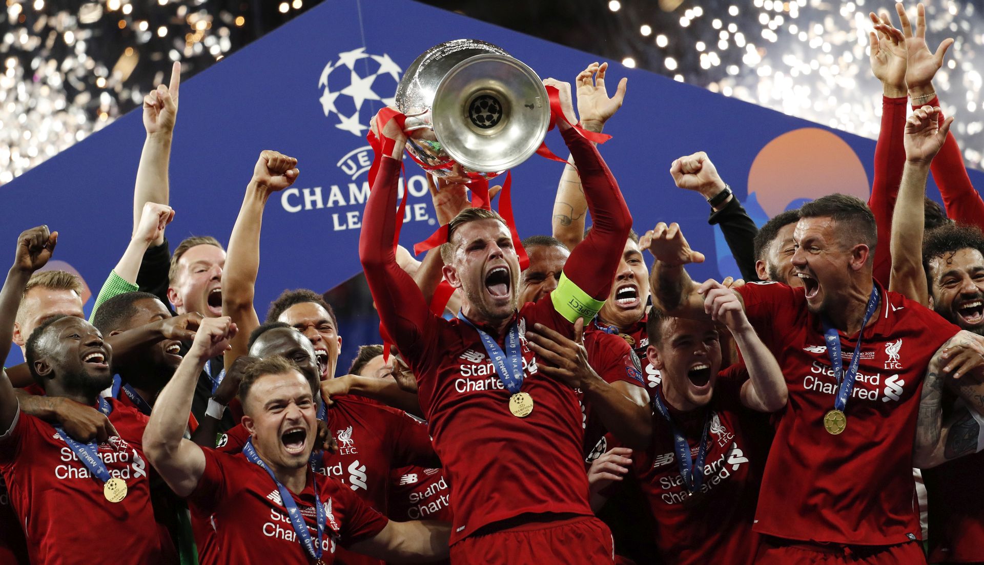 epa07619074 Liverpool FC captain Jordan Henderson lifts the trophy after the UEFA Champions League final between Tottenham Hotspur and Liverpool FC at the Wanda Metropolitano stadium in Madrid, Spain, 01 June 2019. Liverpool won 2-0.  EPA/Emilio Naranjo