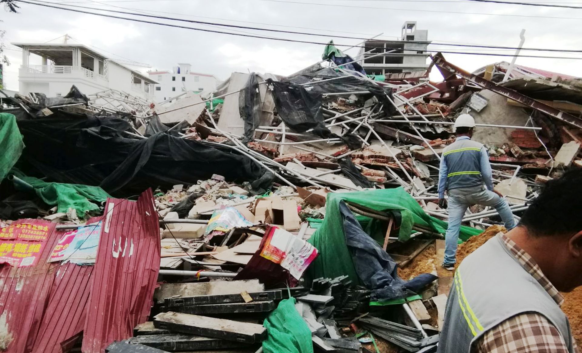 epa07665074 A Cambodian rescue team performs search and rescue duties at the site of a collapsed building at a construction site in Preah Sihanouk province, Cambodia, 22 June 2019. A new seven-story building owned by a Chinese company, collapsed in Preah Sihanouk province, killing at least three workers and leaving 18 workers wounded.  EPA/ROS PINA