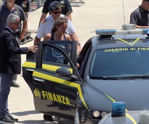 epa07686966 Rescue ship 'Sea-Watch 3' captain Carola Rackete (C), who is being held on charges of abetting immigration and ramming a police cutter, boards a car of the Guardia di Financia upon her arrival at Porto Empedocle, Italy, 01 July 2019. German captain Carola Rackete was arrested on 29 June reportedly after violating orders from the Italian Finance Police and entering the port of Lampedusa while ramming a patrol boat on migrant rescue ship 'Sea-Watch 3'.  EPA/PASQUALE CLAUDIO MONTANA LAMPO