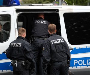 10 July 2019, Saxony, Leipzig: A policeman stands in front of a restaurant in as part of a raid against suspects involved in a gang facilitating marriages of convenience. Photo: Sebastian Willnow/dpa-Zentralbild/dpa