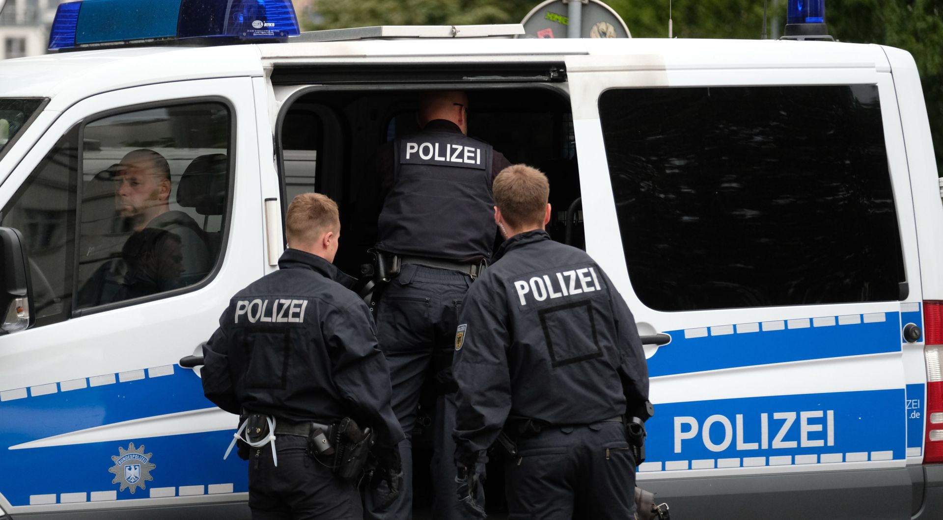 10 July 2019, Saxony, Leipzig: A policeman stands in front of a restaurant in as part of a raid against suspects involved in a gang facilitating marriages of convenience. Photo: Sebastian Willnow/dpa-Zentralbild/dpa
