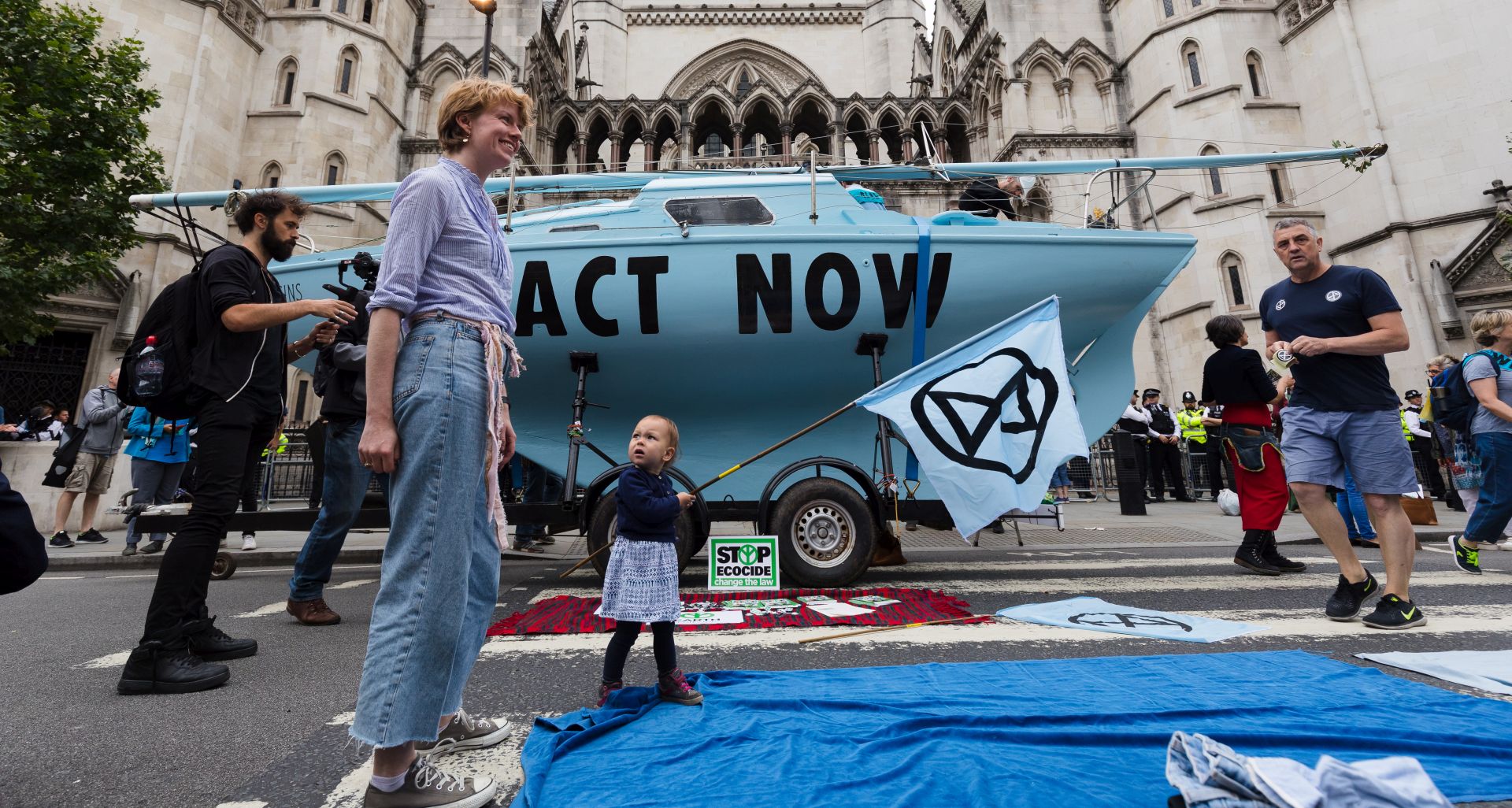 epa07718200 Environmental protesters in front of a blue boat belonging to Extinction Rebellion outside the Royal Courts of Justice this morning where Extinction Rebellion climate change protesters have blocked the road in London, Britain, 15 July 2019. Climate change protests are taking place across five UK cities this week in a series of 'Summer Uprising' actions that are calling for the government to act on cutting emissions.  EPA/VICKIE FLORES