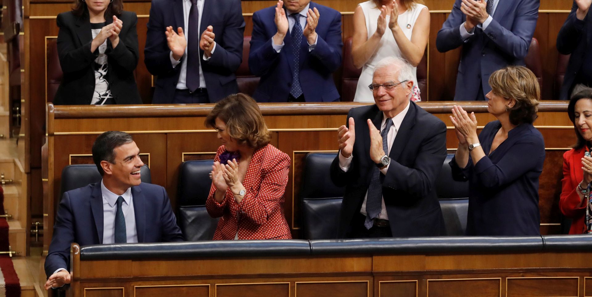 epa07739554 Spanish acting Prime Minister and aspirant for re-election Pedro Sanchez (L, front) smiles as acting Deputy Prime Minister Carmen Calvo (2-L, front); acting Foreign Affairs Minister, Josep Borrell (3-L, front), and his party's MPs applaud after he delivered a speech during the second and last investiture vote at Lower Chamber of Spanish Parliament in Madrid, Spain, 25 July 2019. Sanchez faces his re-election vote at Lower Chamber without enough support from other parties, as the socialists have no reached an agreement with left coalition Unidas Podemos (United, We Can) yet.  EPA/BALLESTEROS