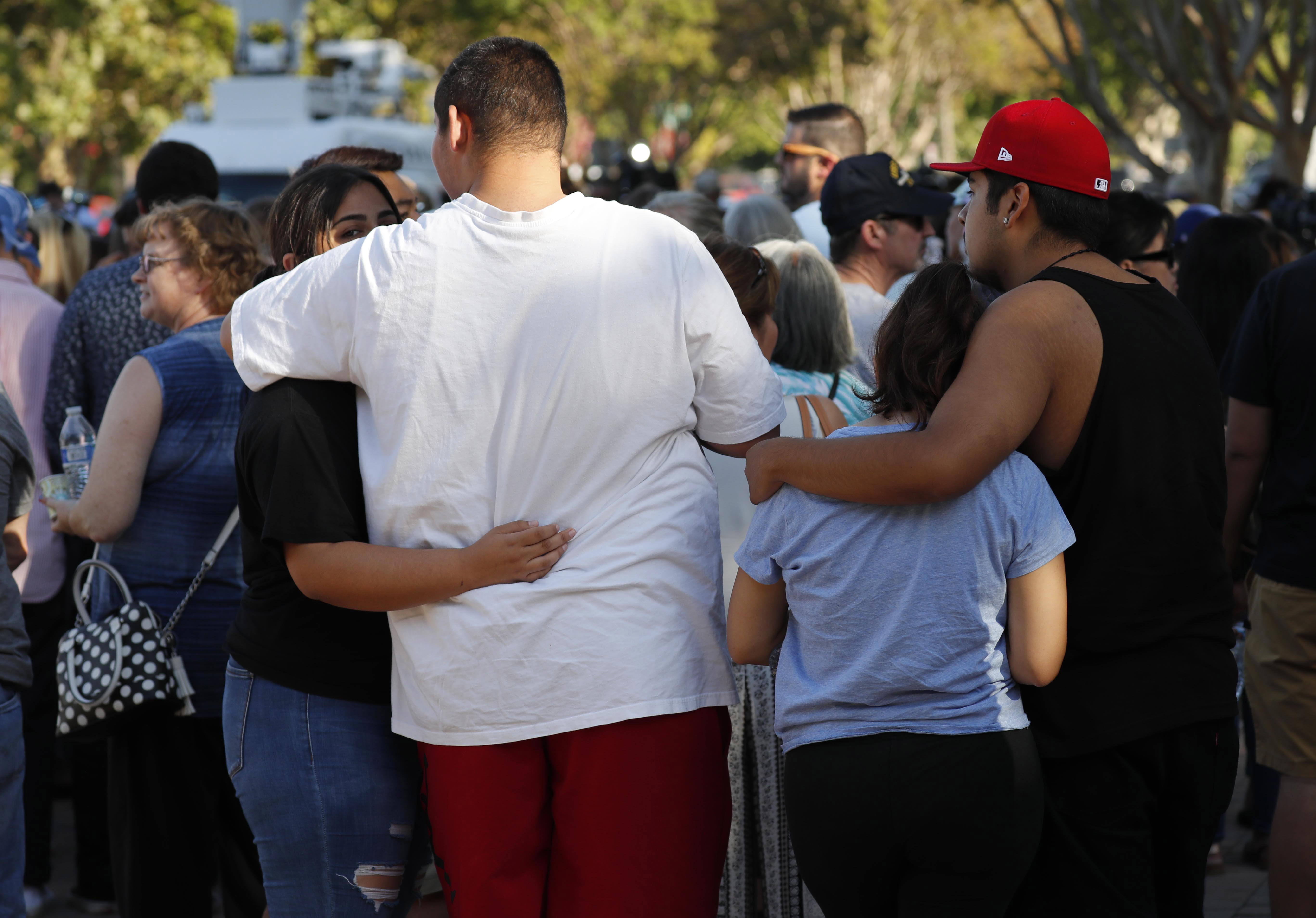 epa07748208 Residences of Gilroy and surrounding communities gather behind the Gilroy City Hall during a vigil for victims of the Gilroy Garlic Festival shooting in Gilroy, California, USA, 29 July 2019. A gunman opened fire on visitors at the garlic festival, killing at least three people and injuring 12 others. Police shot and killed one suspect, 19-year-old Santino William Legan.  EPA/JOHN G. MABANGLO