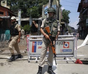 epa07753104 An Indian paramilitary soldier stands guard as policemen walk past in Srinagar, the summer capital of Indian Kashmir, 02 August 2019. According to local news reports over 280 companies of paramilitary forces are being deployed in the Kashmir valley.  EPA/FAROOQ KHAN