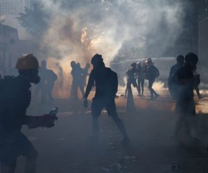 epa07757605 Anti-extradition protesters react after police fired tear gas at them in the Admiralty area of Hong Kong, China, 05 August 2019. Hong Kong is in the midst of a day of citywide strike following a ninth consecutive weekend of multiple anti-extradition rallies and intense clashes between demonstrators and police over the now suspended extradition bill to China.  EPA/JEROME FAVRE