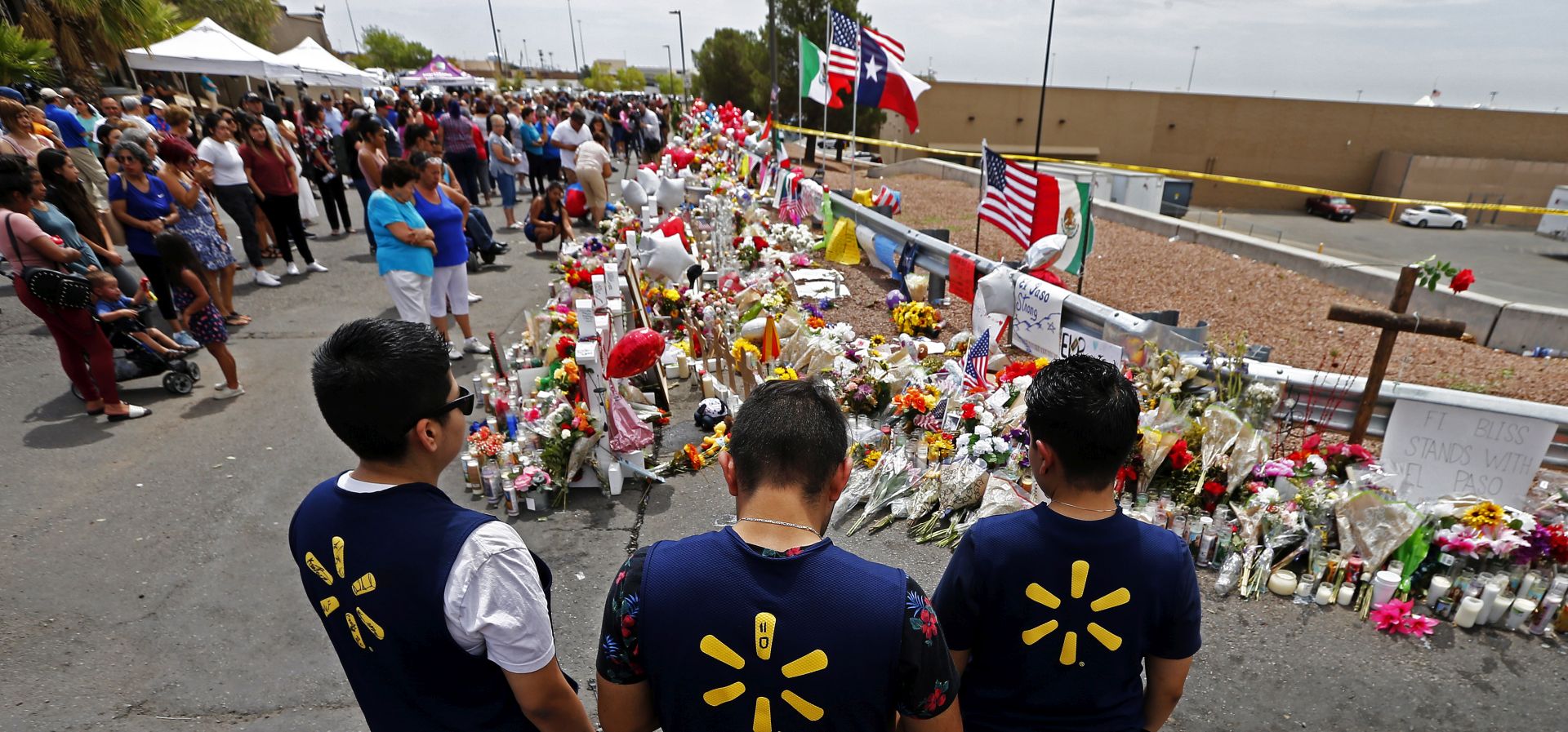 epa07759591 Three Walmart employees pause while visiting the make shift memorial after the mass shooting that happened at a Walmart in El Paso, Texas, USA, 06 August 2019. Twenty two people were killed and 26 injured during a mass shooting at the Walmart on 03 August 2019. Prosecutors said they will seek the death penalty against Patrick Crusius, a 21-year-old man, accused of the mass shooting.  EPA/LARRY W. SMITH