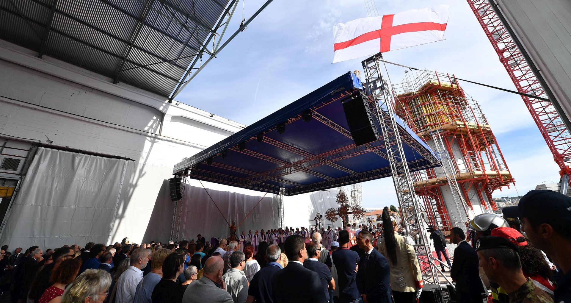 epa07772549 A St. George's Cross (croce di San Giorgio) flag, symbol of the city of Genoa, waves during a memorial ceremony on the first anniversary of the Morandi highway bridge collapse, in Genoa, northern Italy, 14 August 2019. The motorway bridge partially collapsed on 14 August 2018, killing 43 people.  EPA/LUCA ZENNARO