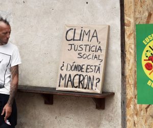 epa07792018 A protestor stands near a portrait of French President Emmanuel Macron allegedly stolen in a French city hall covered by paper and with 'Climate, Social justice. Where is Macron?' written during an anti-G7 demonstration in Bayonne, near Biarritz, France, 25 August 2019, on the second day of the G7 summit. Protestors will march with more than 120 portraits of Macron allegedly taken off the walls of French city halls. The G7 Summit runs from 24 to 26 August in Biarritz.  EPA/GUILLAUME HORCAJUELO