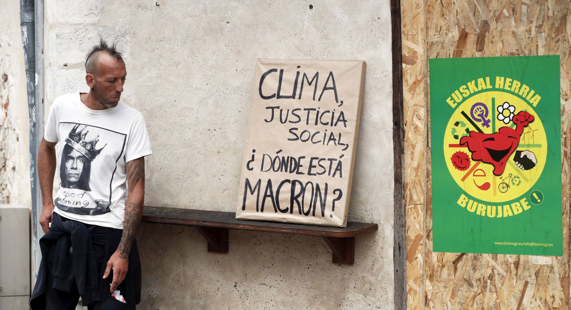 epa07792018 A protestor stands near a portrait of French President Emmanuel Macron allegedly stolen in a French city hall covered by paper and with 'Climate, Social justice. Where is Macron?' written during an anti-G7 demonstration in Bayonne, near Biarritz, France, 25 August 2019, on the second day of the G7 summit. Protestors will march with more than 120 portraits of Macron allegedly taken off the walls of French city halls. The G7 Summit runs from 24 to 26 August in Biarritz.  EPA/GUILLAUME HORCAJUELO