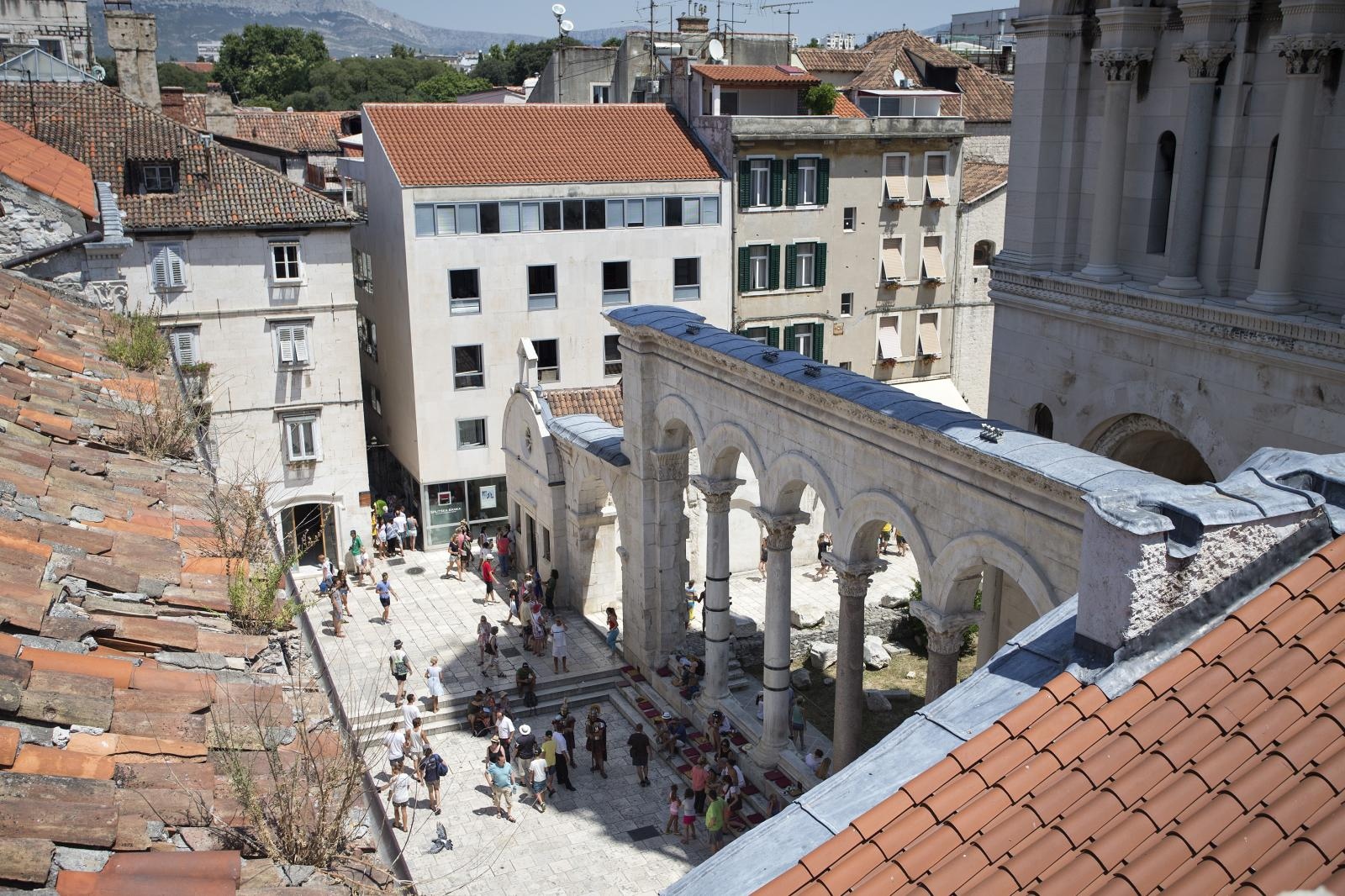 16.07.2015., Split - Vestibul je bio ulazna dvorana u Dioklecijanov stan. To je prostor za odabrane gradjane, prvenstveno veleposlanike. Kruzni prostor sa zaobljenim stropom svojom visinom i impresivnoscu trebao je pripremiti posjetitelje za susret s vladarom. Izvana izgleda kao velika kocka, a unutra je kruzna dvorana  koja je bila ukrasena mramornim plocama. Na vrhu se nalazila kupola s mozaikom, a u nisama su bile skulpture. Pogled na Peristil s terase Etnografskog muzeja.
Photo: Davor Puklavec/PIXSELL